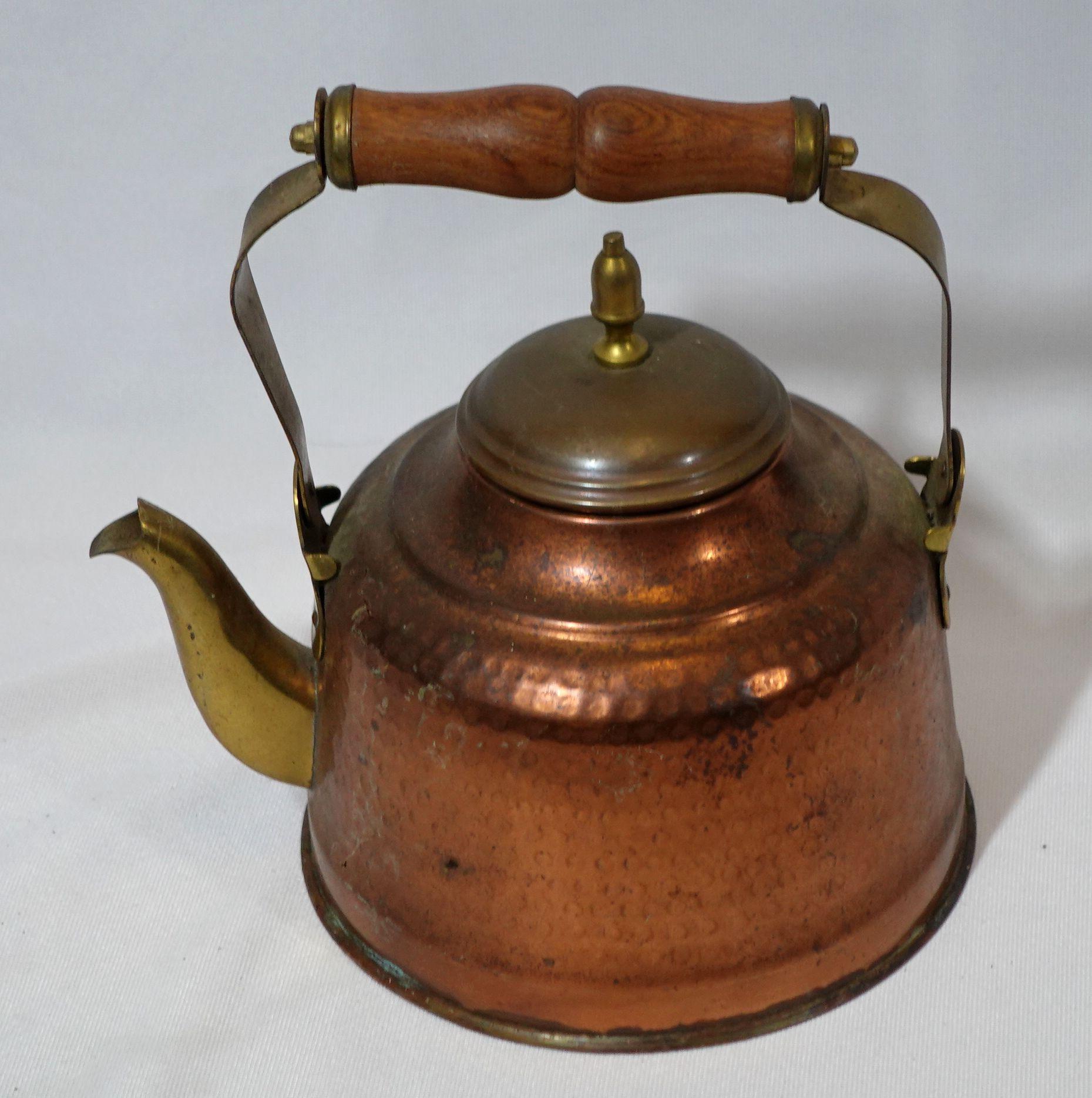 Hand-hammered copper and brass tea kettle made in India from the early 20th century, very well hand-made with delicate craftsmanship, and highly collectible antique.
