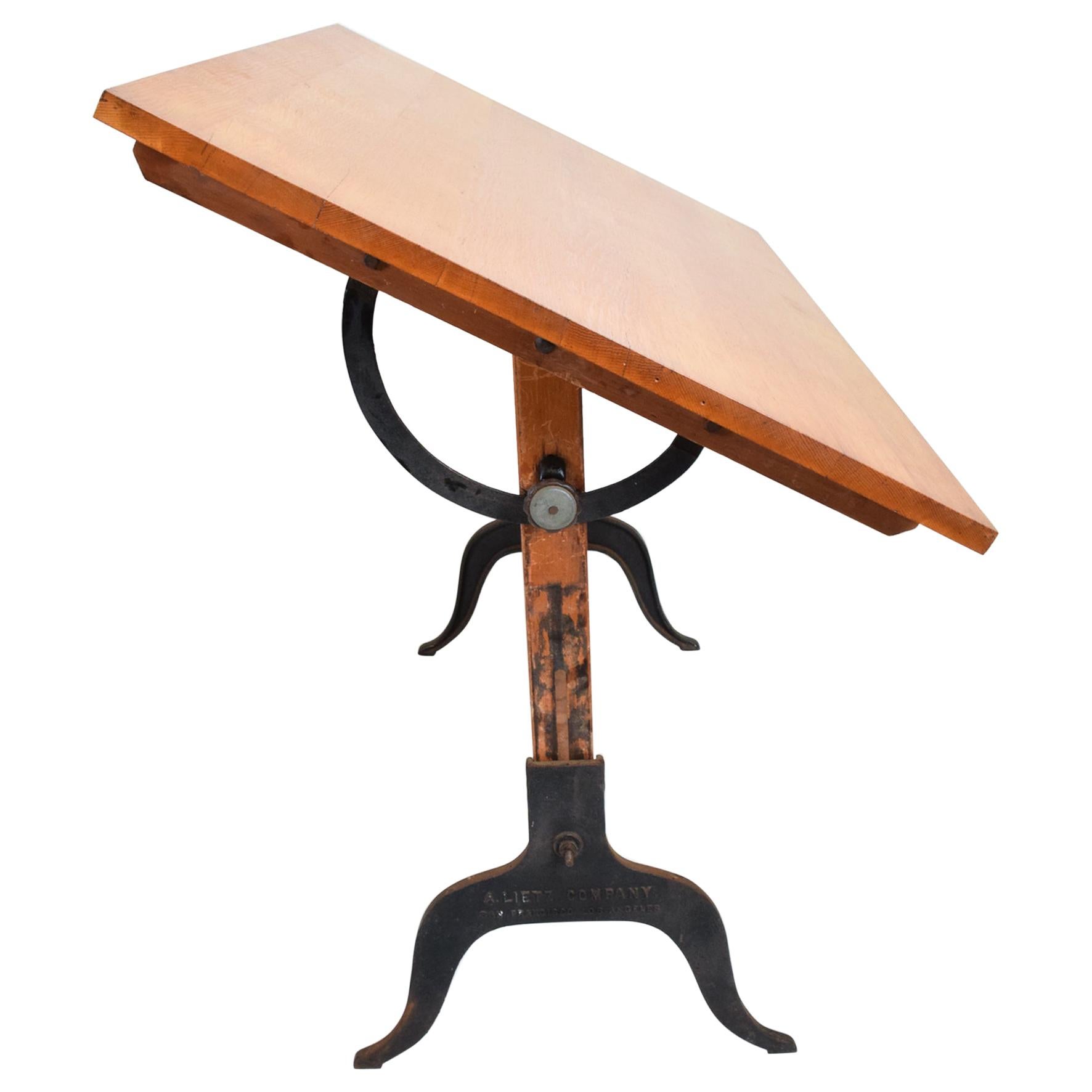 
1940s  Antique A. Lietz Company drafting table in maple wood & cast iron 
Art Deco San Francisco CA
Drafting table is fully adjustable. 
Solid maple wood with cast iron legs. 
Original brass label present.
48 H (adjustable) x 35.63 D x 59.63