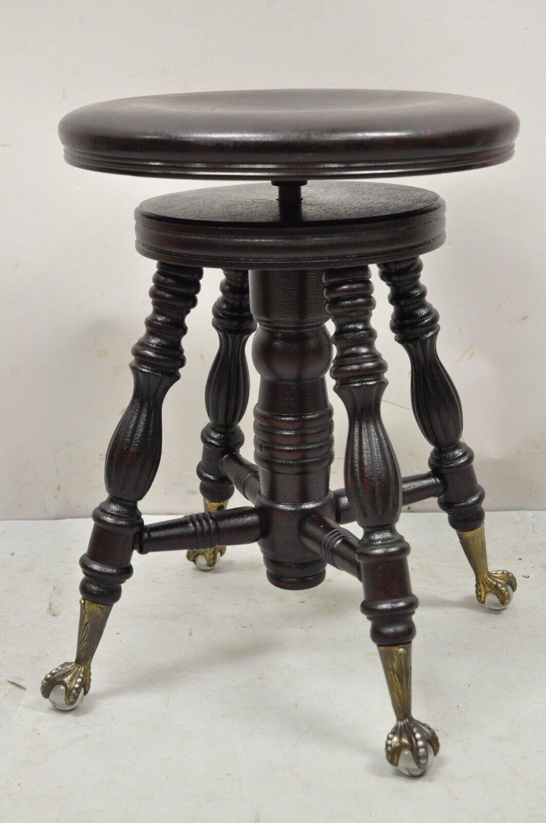 Antique A. Merrian Co Victorian piano stool glass ball brass claw feet. Item features glass ball feet, turn carved stretcher base, solid wood construction, nicely carved details, very nice antique item. Circa 19th century. Measurements: 19.5
