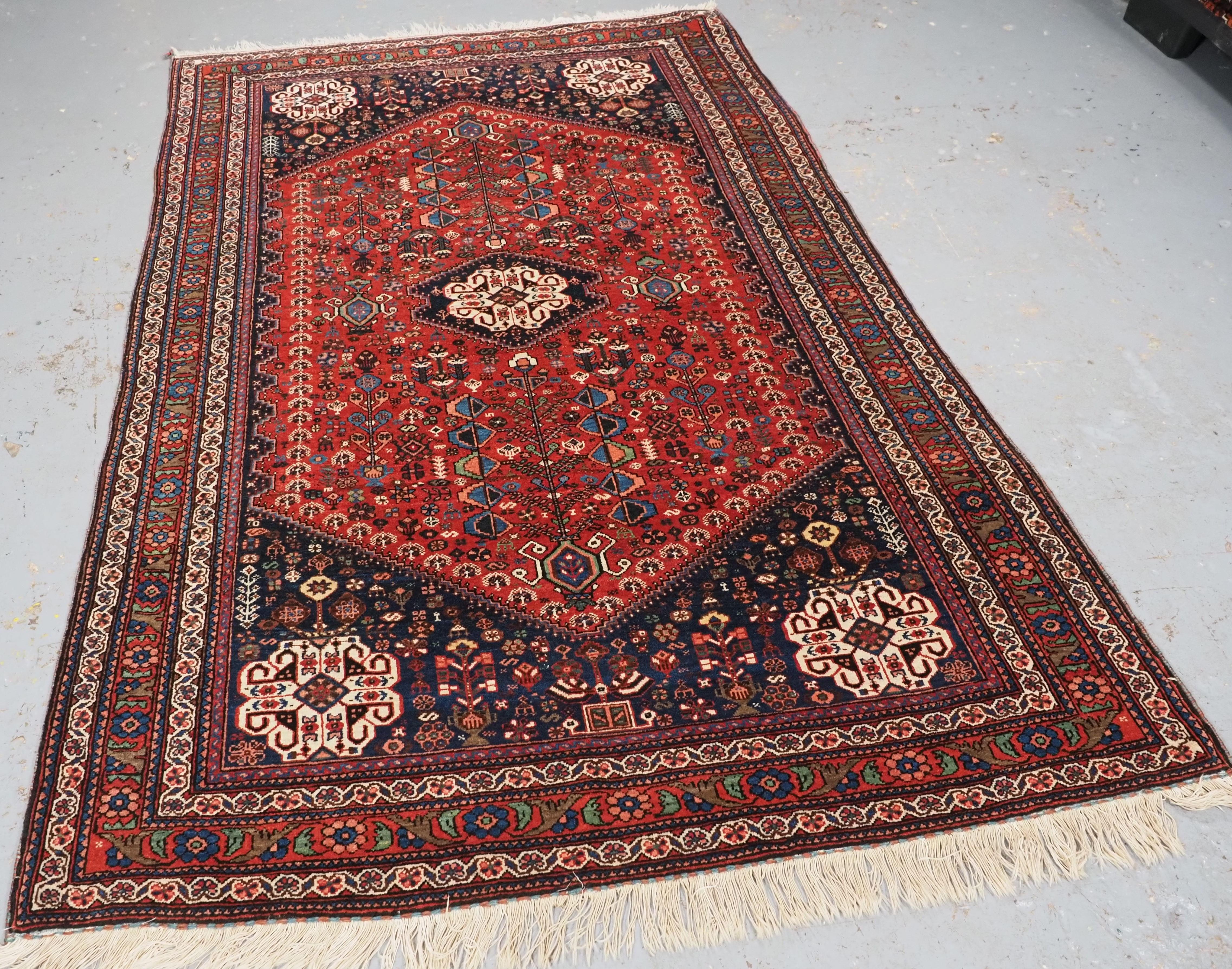 Size: 6ft 9in x 4ft 8in (206 x 141cm).

Antique Abedeh rug with the tribal medallion design.

Circa 1900/20.

The rug is of a traditional tribal design with a small central medallion, repeated in each of the corners; the field is filled with tribal