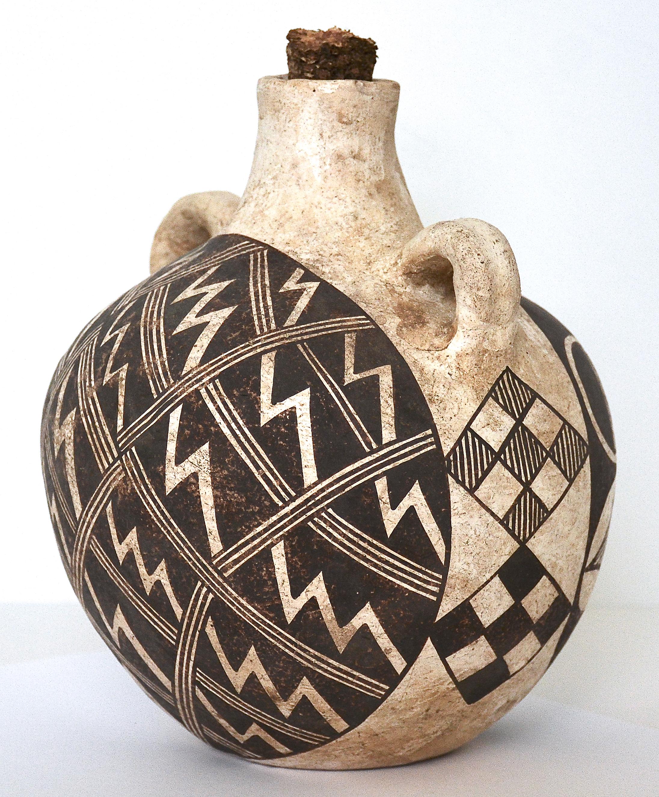Polychrome pottery canteen
Acoma
1920
Measures: 8 inches height x 6 inches diameter.
Clay, mineral pigments, corn cob. 

A wonderful example of an antique polychrome Acoma Pueblo Pottery Canteen circa 1920, with bifurcated geometric and floral