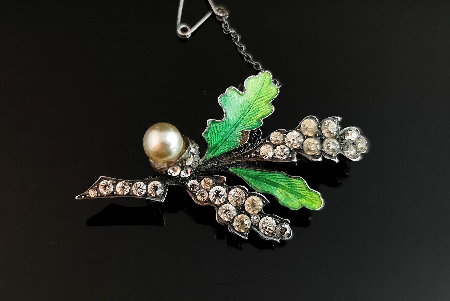 An attractive and unusual antique sterling silver oak leaf and acorn brooch.

A heavy sterling silver oak tree branch with oak leaves and an acorn, two leaves are enamelled with a rich green guilloche enamel.

The remaining leaves and base of the