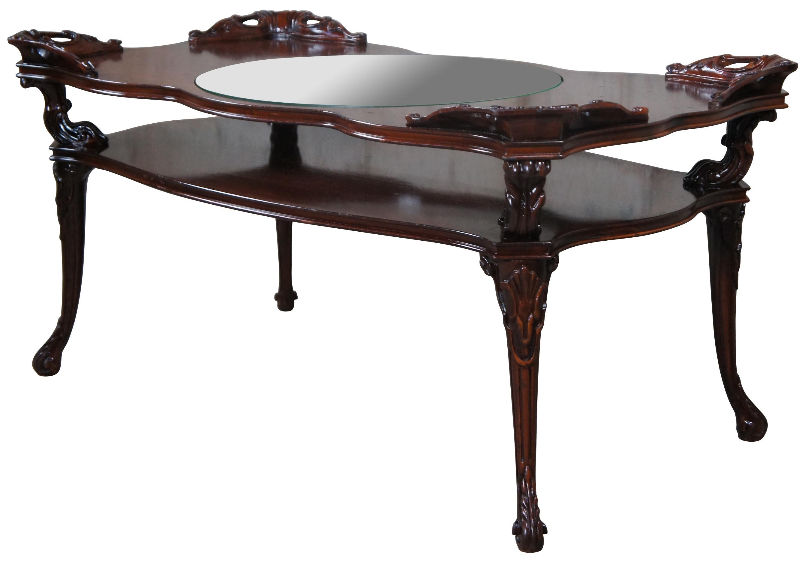 Adams Always Fine Furniture Louis XV style tiered coffee table, circa 1930-40s. Beautifully designed with acanthus and scalloped details. Features an inset round glass top resting on a raised wooden top supported by 