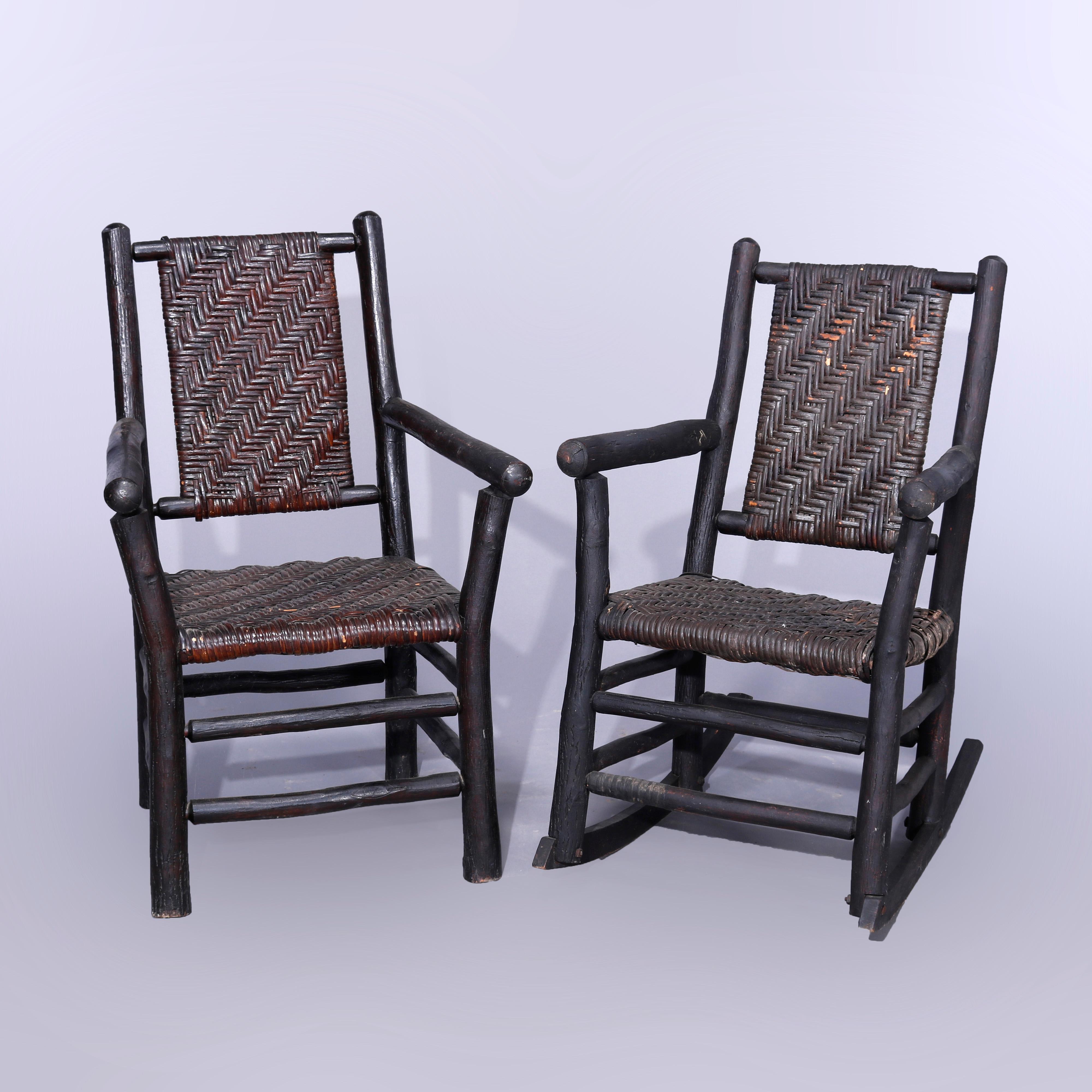 An antique Adirondack chair and rocker set in the manner of Old Hickory offer stick form frames with woven reed seats and backs, c1920

Measures - chair 36'' H x 23.75'' W x 24'' D, seat height 15.5