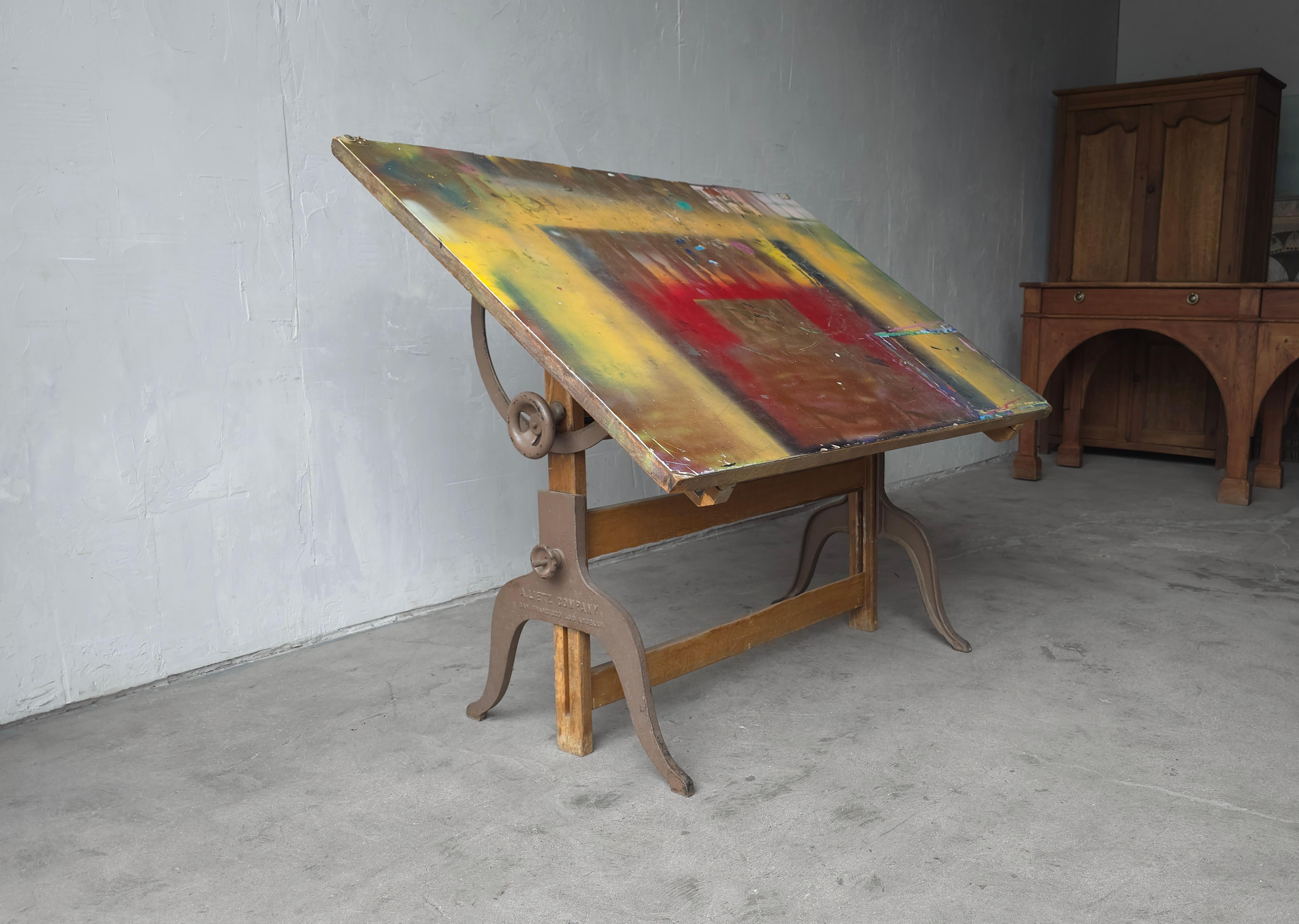 A uniquely worn and aged adjustable artists or architects drafting table from the early 20th Century.  Designed by the A. Lietz Company.

Both the angle of the top and the height are fully adjustable.  Height is 33