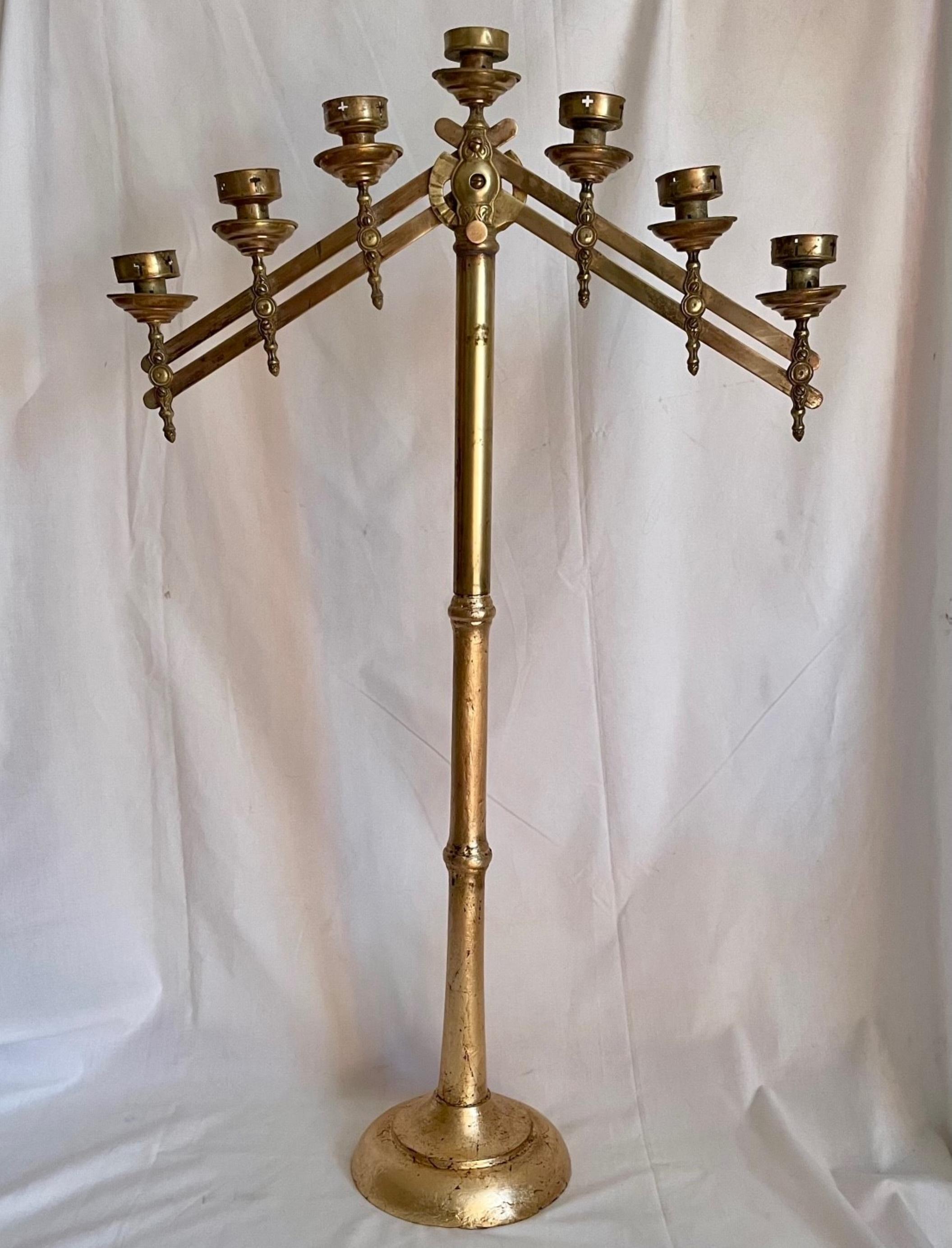 Antique adjustable brass floor candelabra

This floor candelabra with adjustable arms has 7 matching cups with drip pans. The patinated brass candelabra stands on a round footed giltwood base. The decorative arms extend to various directions and