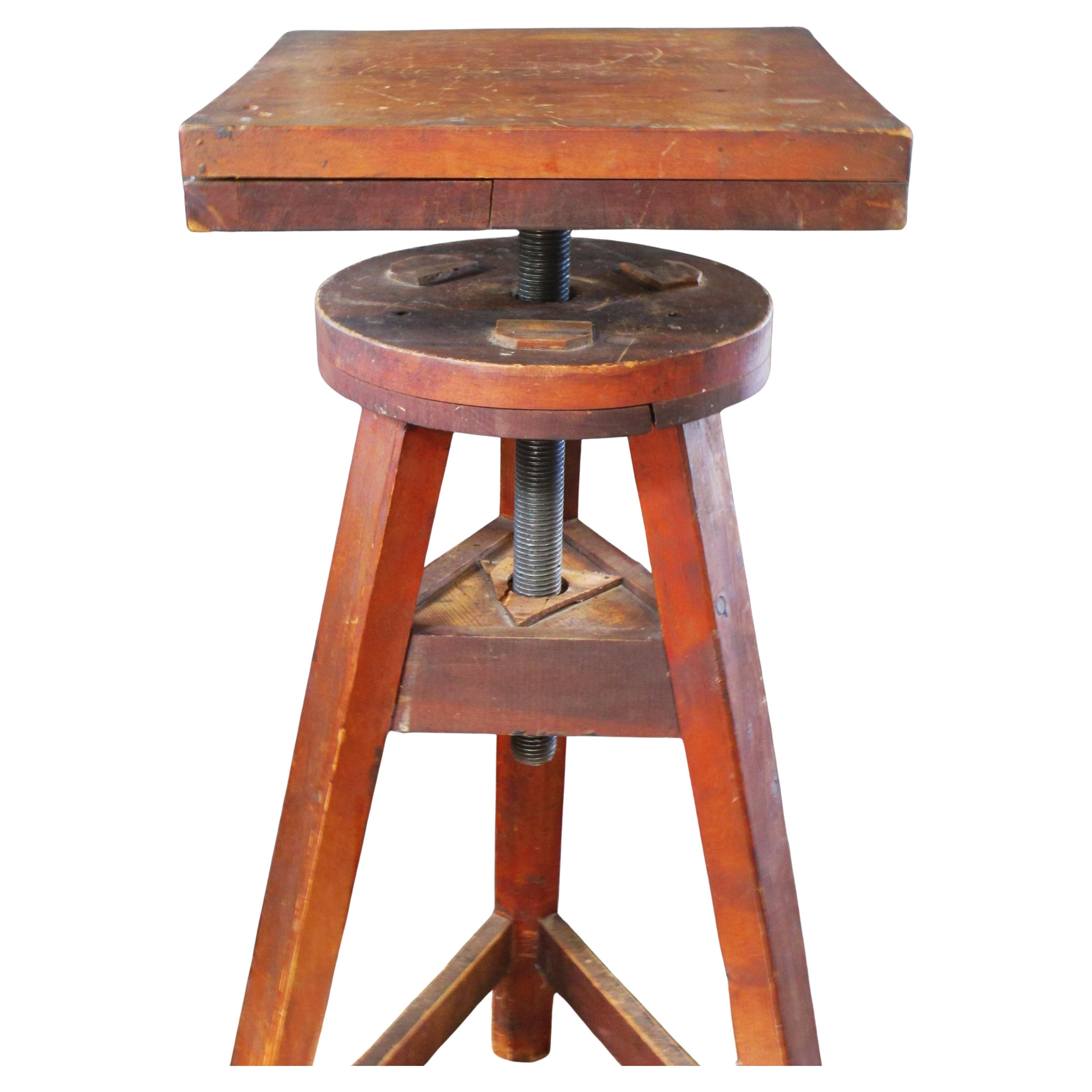 Socle de sculpteur ancien en bois à pied tripode avec tige centrale filetée en acier massif qui tourne / soulève et abaisse le plateau en bois. Structure en bois joliment patinée à l'ancienne avec une construction à chevilles. 42 1/2