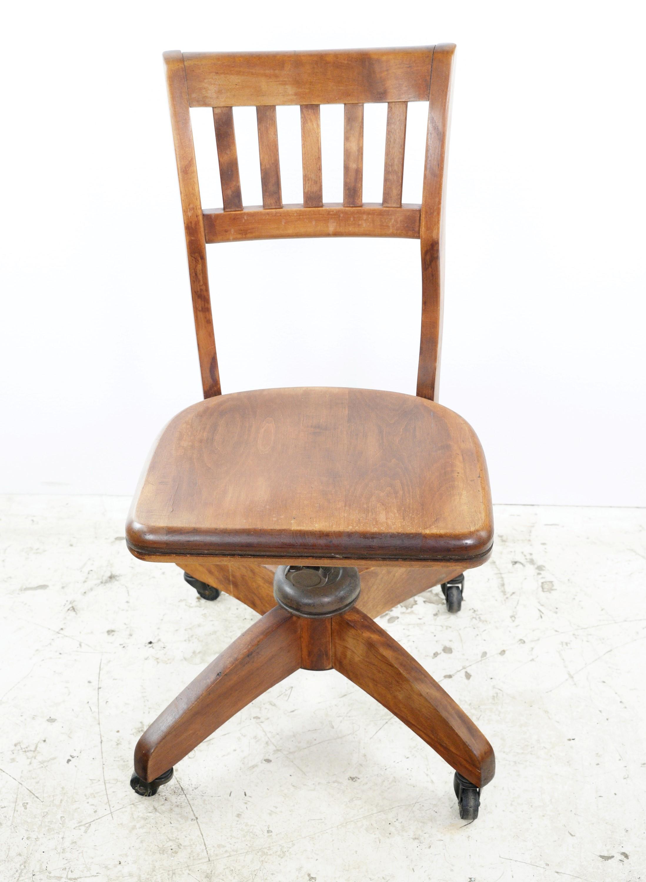 The antique adjustable height wooden desk chair with casters combines vintage style with practicality, offering mobility and comfort for productive workspaces. It is in good condition with age appropriate wear. Please note, this item is located in