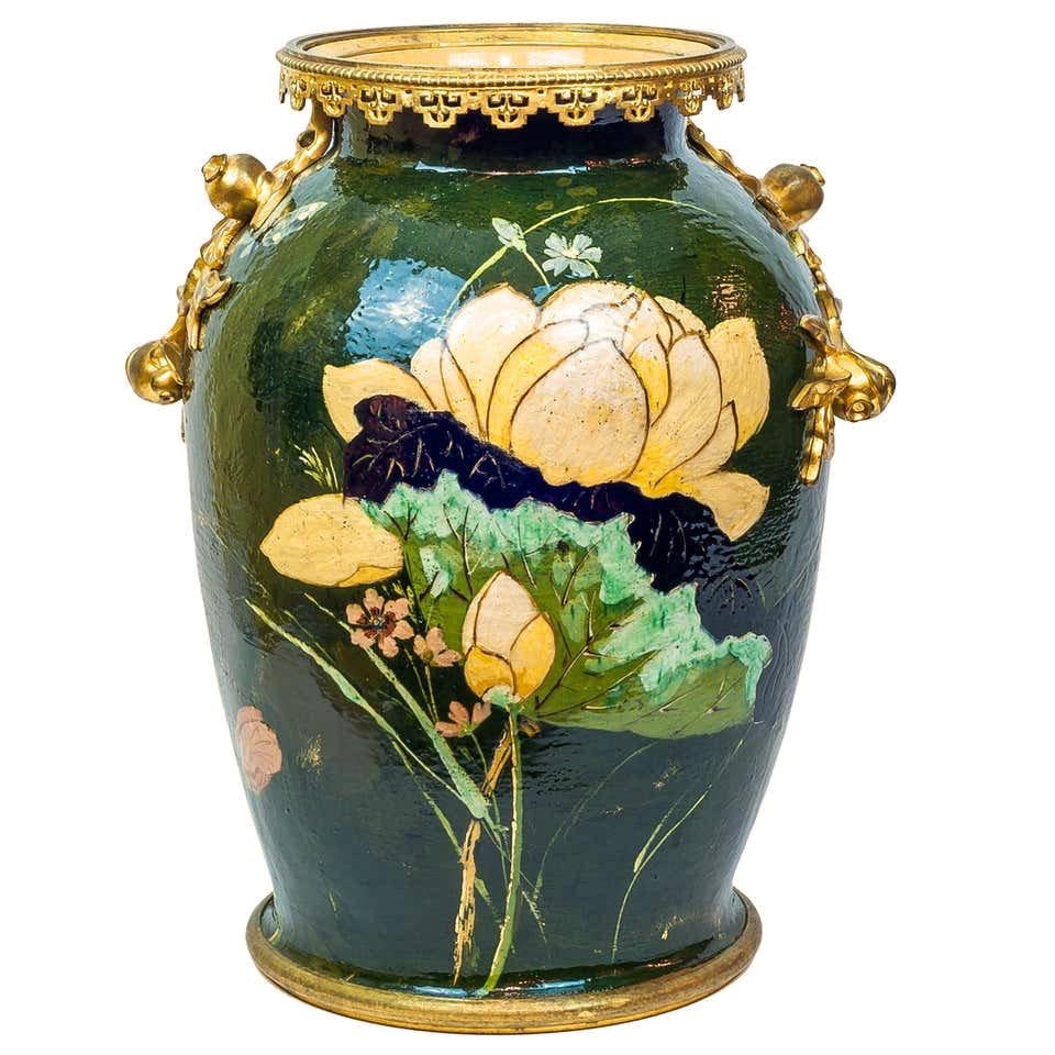 Our very large stoneware vase with polychrome glazed finish in the Aesthetic style measures 21.5 in (54.6 cm) tall and features gilt bronze mounts including berries and a pierced rim. Apparently unsigned.