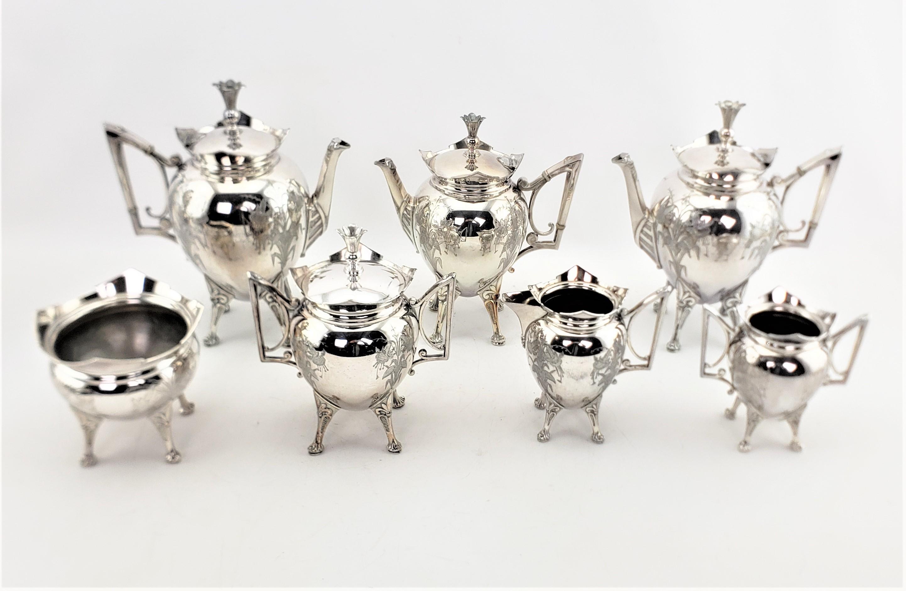 This antique silver plated tea set was made by the Meridian Company of the United States in approximately 1890 in the period Aesthetic Movement style. The set is composed of two teapots, a coffee pot, a covered sugar bowl and creamer, and two side