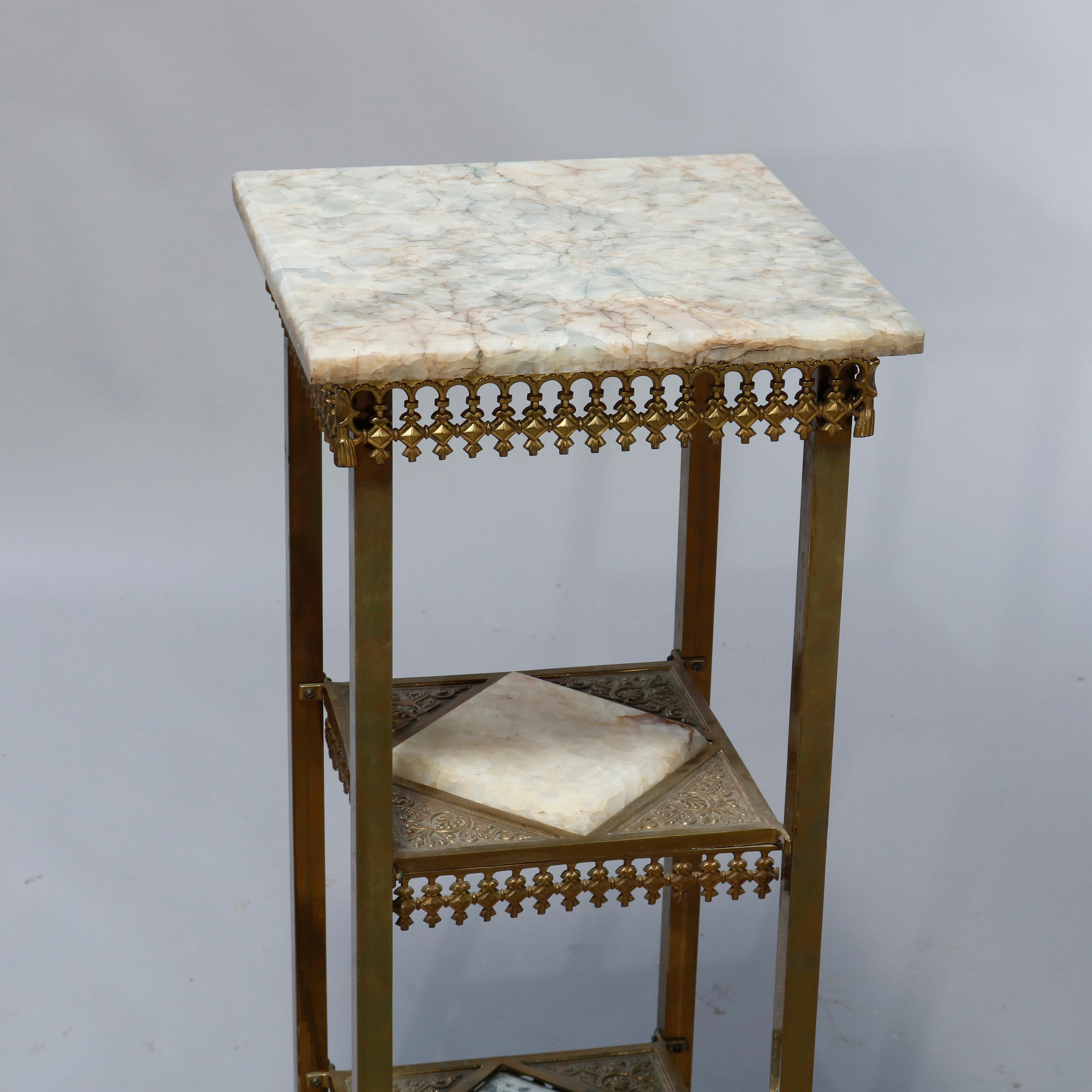 An antique Aesthetic Movement plant stand offers cast brass frame having onyx top surmounting two foliate cast lower tays with inset onyx, pierced skirts and raised on straight and square legs terminating in stylized reptile claw feet,