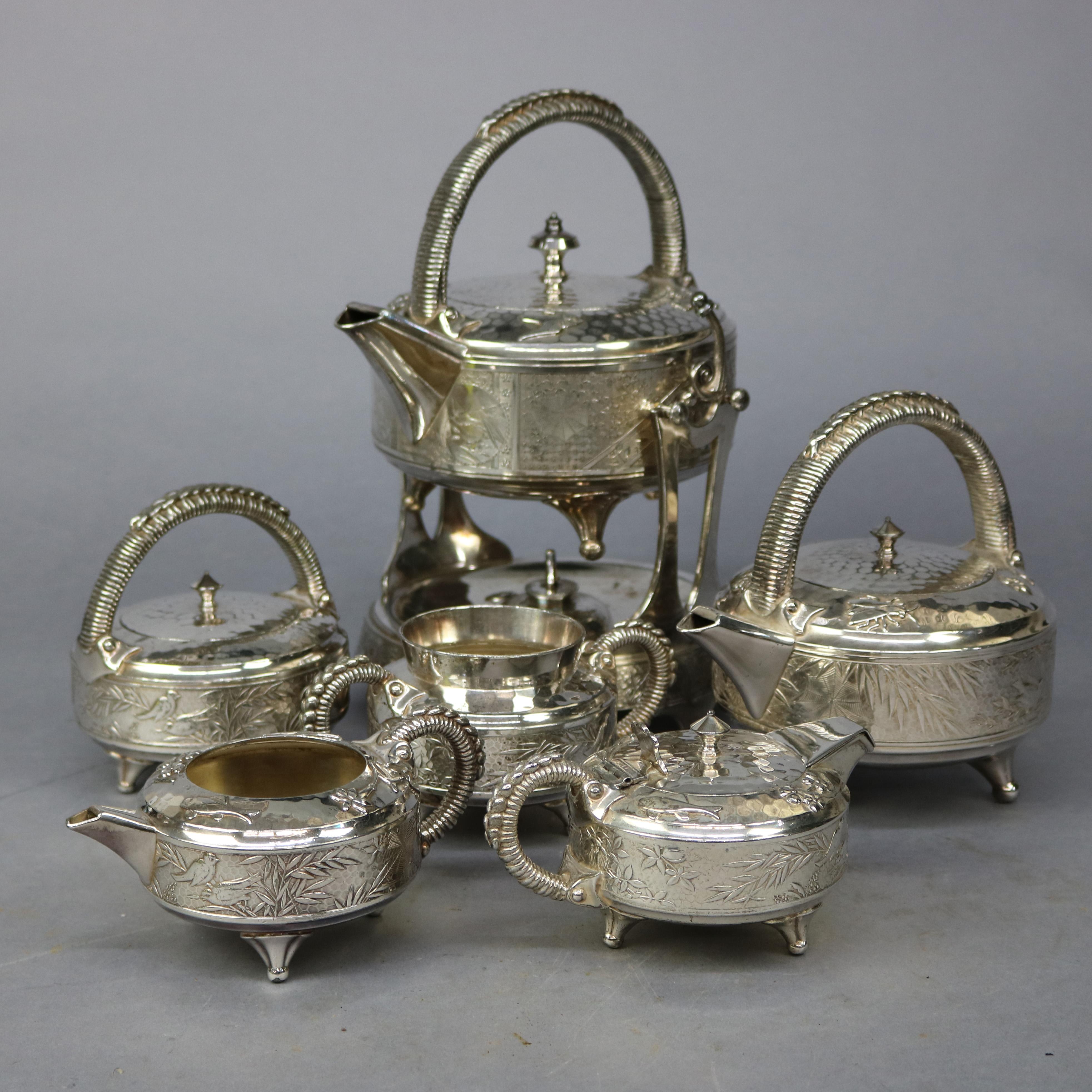 An antique Aesthetic Movement tea set by Rogers offers six pieces of hammered quadruple silver plate elements having embossed garden scenes including birds and butterflies, maker signed as photographed, c1870

Measures - tea pot & heat stand 12''