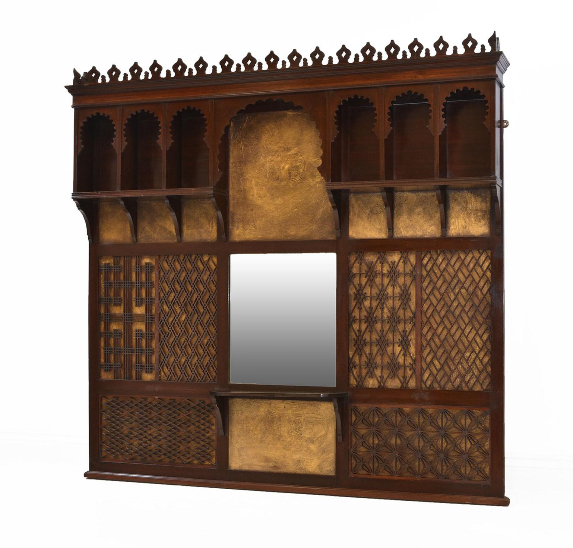 An Aesthetic Movement stained beechwood large overmantle mirror. Circa 1880.

Attributed to Liberty & Co, the mirror has decorative impressed gold colored panels depicting Chinese vases, with over layered various design fret work panels. Above, it