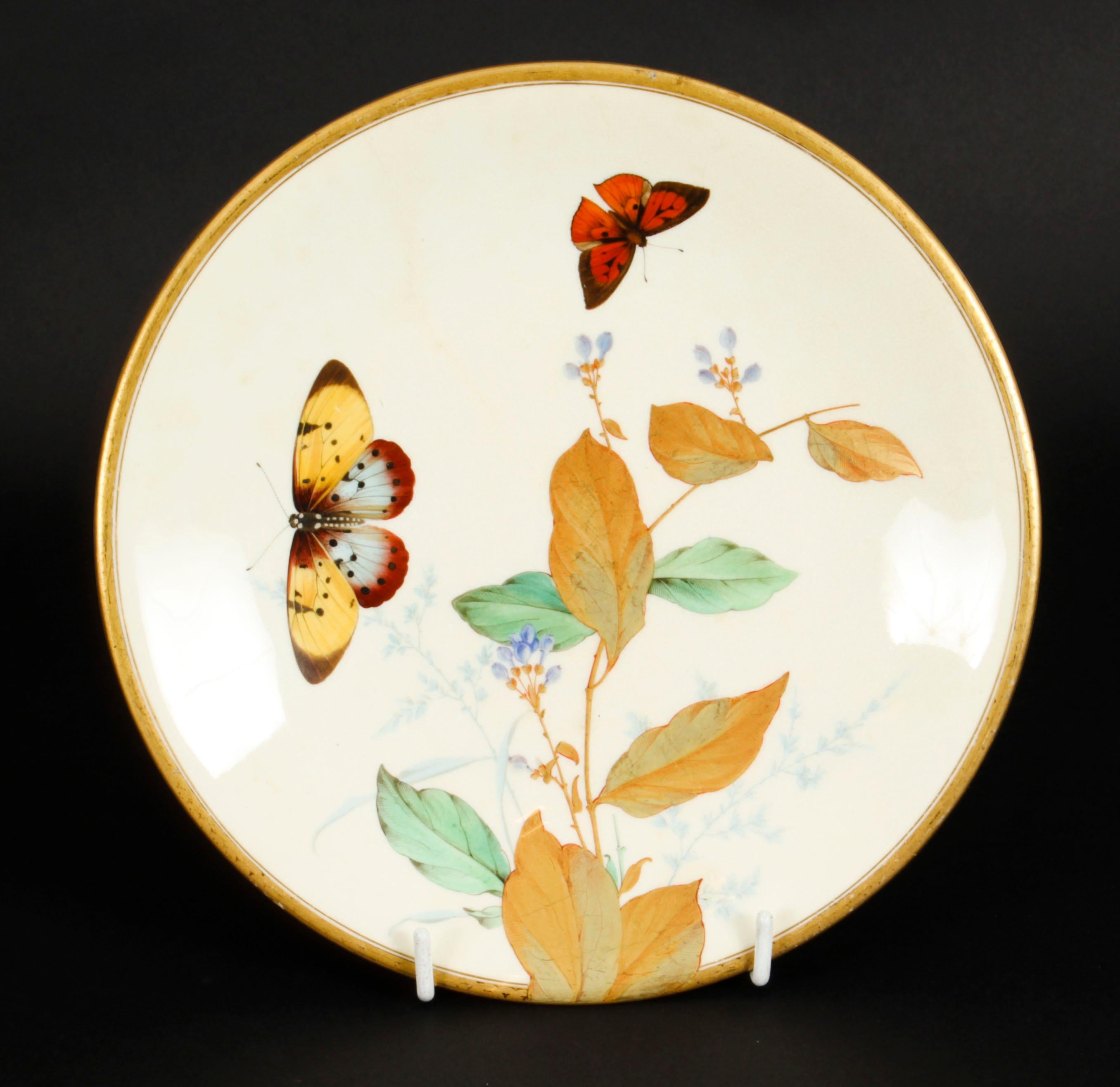 This is a lovely antique Minton Aesthetic Movement porcelain cabinet plate, circa 1880 in date. 

The centre is beautifully hand painted with foliate and floral ornamentation with two butterflie on a cream ground and within a gilt border.

On