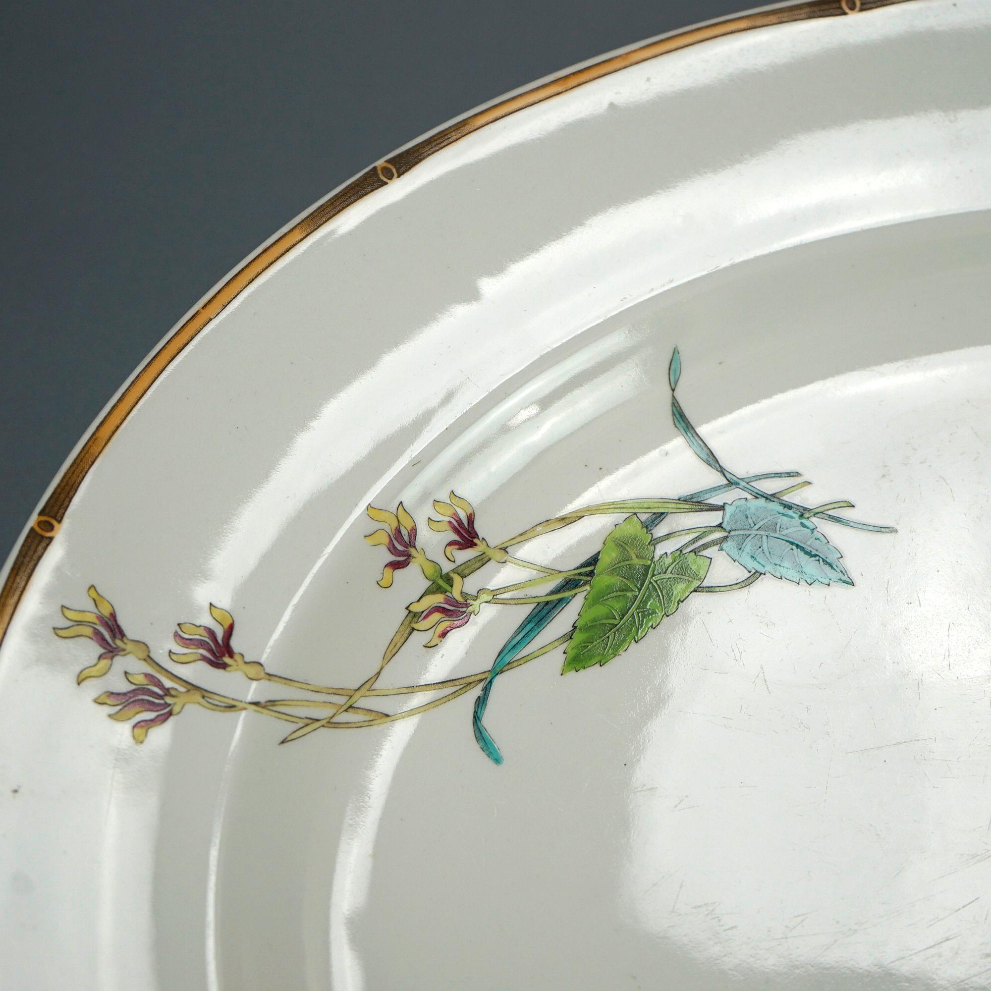 An antique Aesthetic Movement serving platter offers porcelain construction in oval form with bird and garden elements, gilt highlights throughout, 19th century

Measures- 2.5'' H x 21'' W x 17.5'' D.