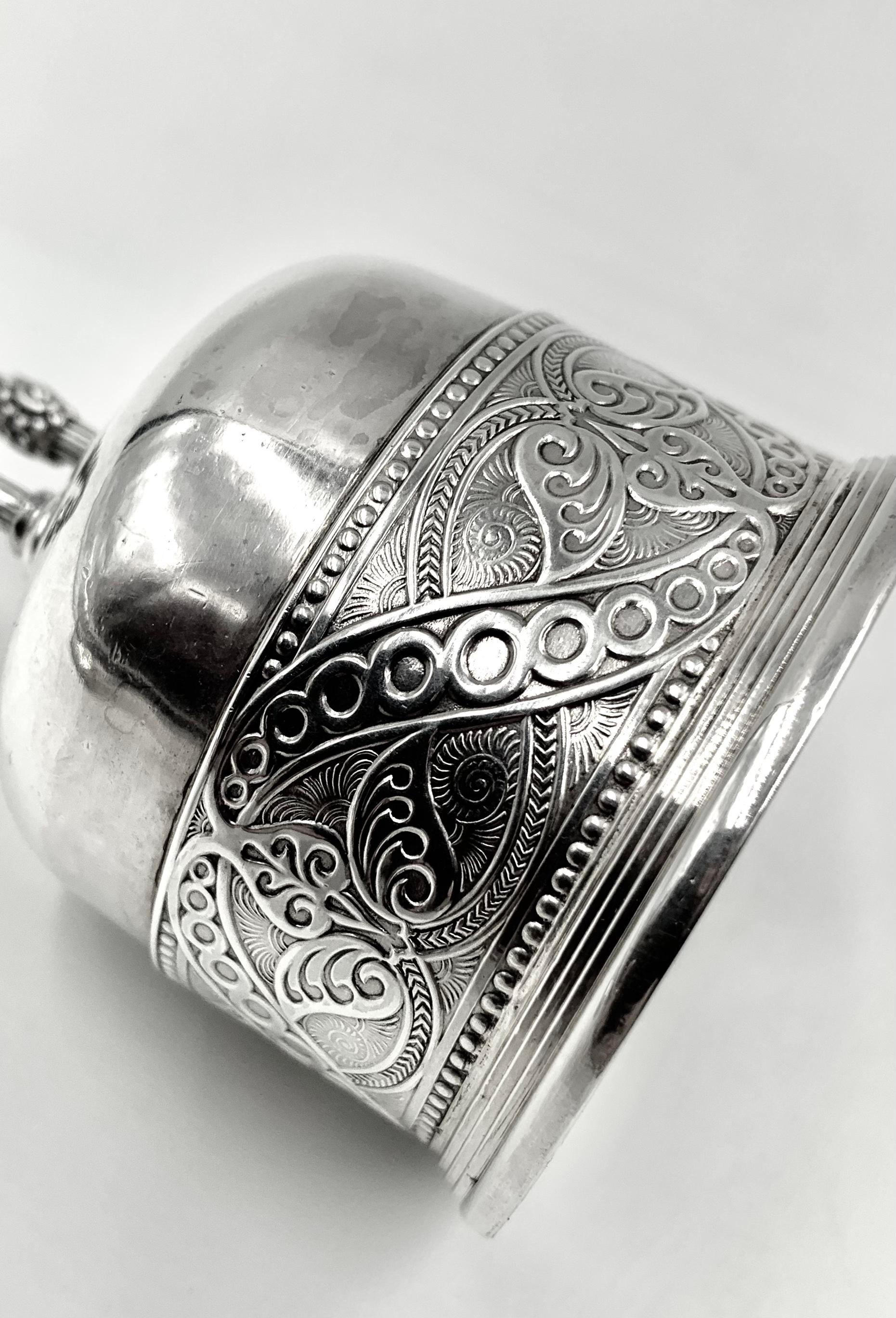 Rare cloche de table Tiffany & Co. en argent sterling d'époque Edward Moore, 1873-1891, sur pied.
La cloche est dotée d'une haute poignée en forme de U inversé aux détails exceptionnels - un motif cannelé entrecoupé de cinq doubles bandes et de