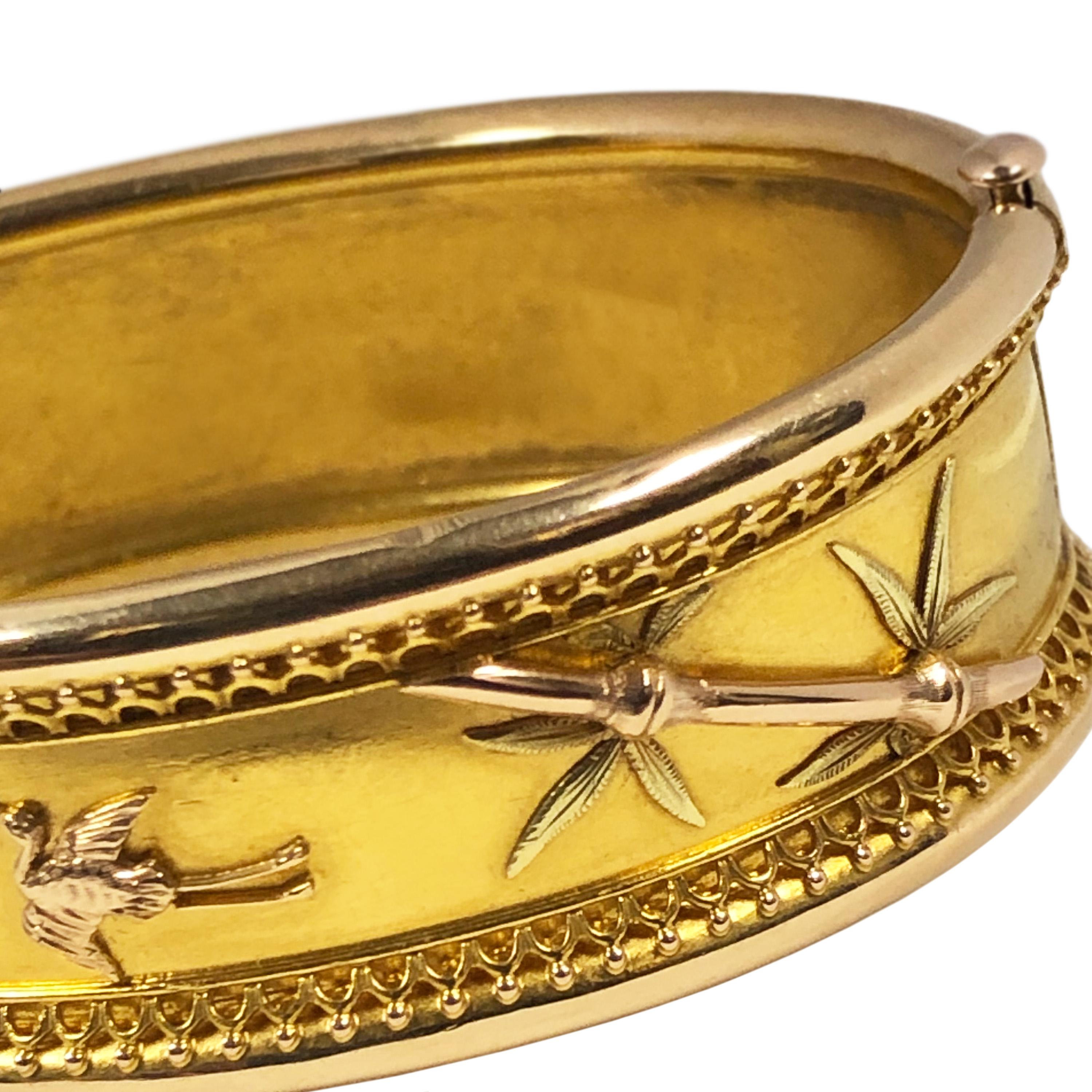 Circa 1880 Aesthetic Movement 14K Yellow Gold Bangle Bracelet, measuring 11/16 inch wide and having applied Red and Green Gold Bamboo plants and Crane Birds. Inside measurement / wrist size 6 1/2 inches. 