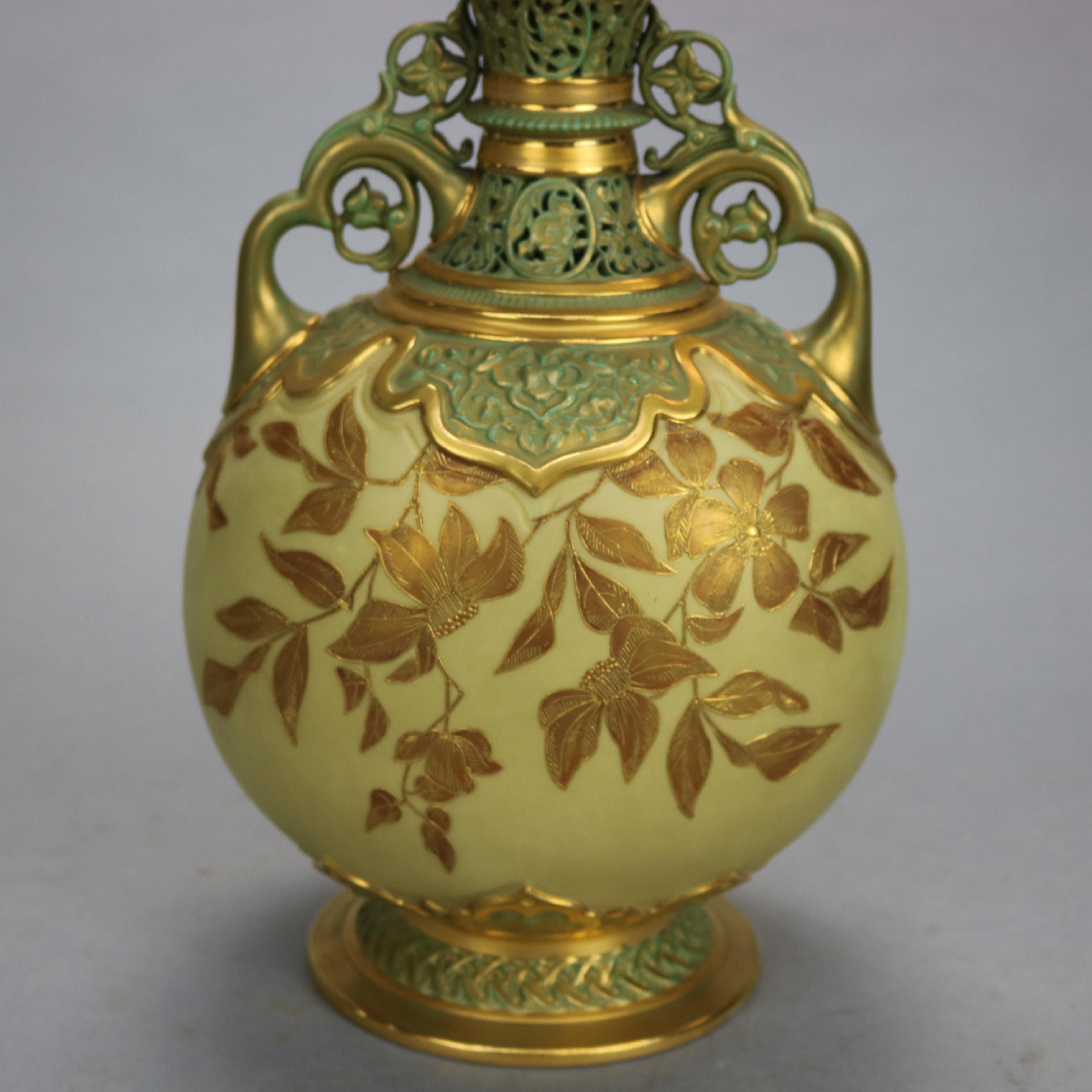 An antique Aesthetic Movement covered urn by Royal Worcester offers porcelain construction with Moorish foliate reticulated neck and collar over bulbous vessel with hand painted foliate decoration and having flanking scroll and floral form double