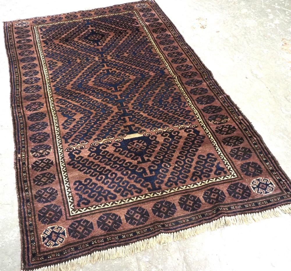 Antique Afghan Adraskhan Baluch rug of traditional ‘Mushwani’ design, the rug is of a warm colour with indigo blue
Circa 1900/20

This group of rugs made in Western Afghanistan, south of Herat; by the Baluch nomads The rug has the traditional