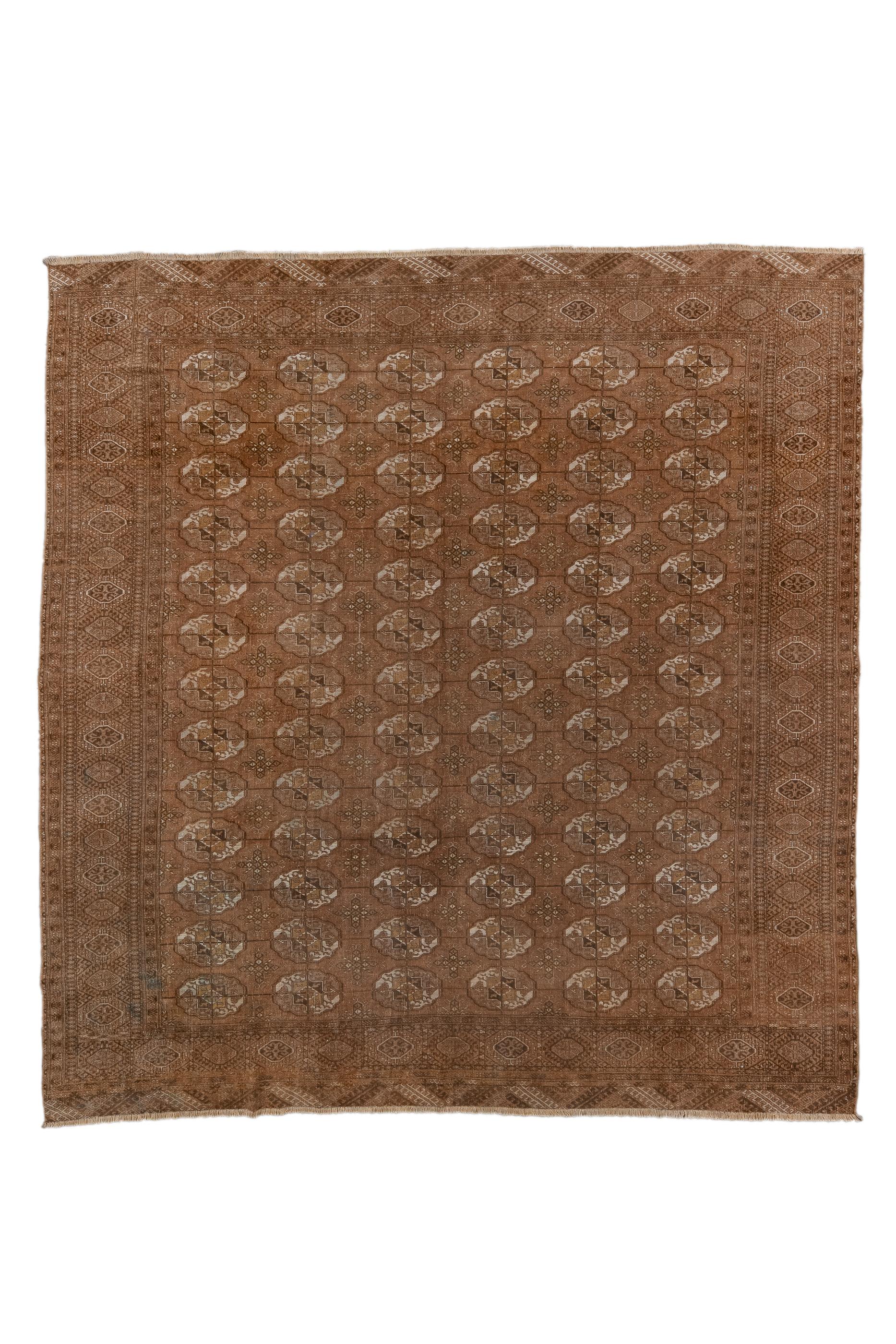 The rusty-red field of this well-woven Central Asian tribal piece shows six columns of connected Tekke tribal guls, with chemche minor guls placed between.  Similar toned border with rayed and flattened octagons bearing central crosses. Narrow elems