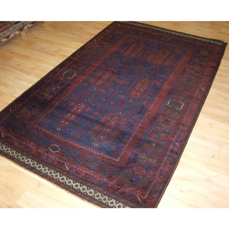 A good Timuri Baluch rug from Western Afghanistan, with very dark indigo blue field and dark, almost aubergine, madder red. The are a small number of highlights in ivory and yellow. The dark charcoal brown is corroded throughout the rug.

The rug