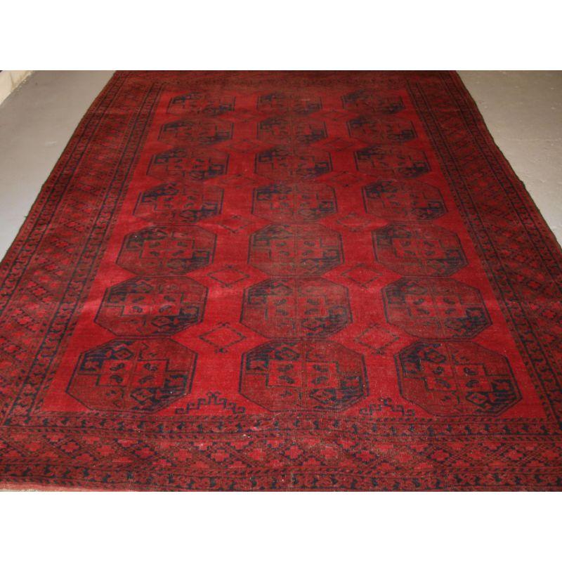 Ein guter afghanischer Dorfteppich mit guter Farbe und einigen Gebrauchsspuren.

Der Teppich hat drei Reihen mit sieben großen Guls auf einem sehr reichen roten Grund. Das Design der Guls ist typisch für die Dörfer in Nordafghanistan.

Der