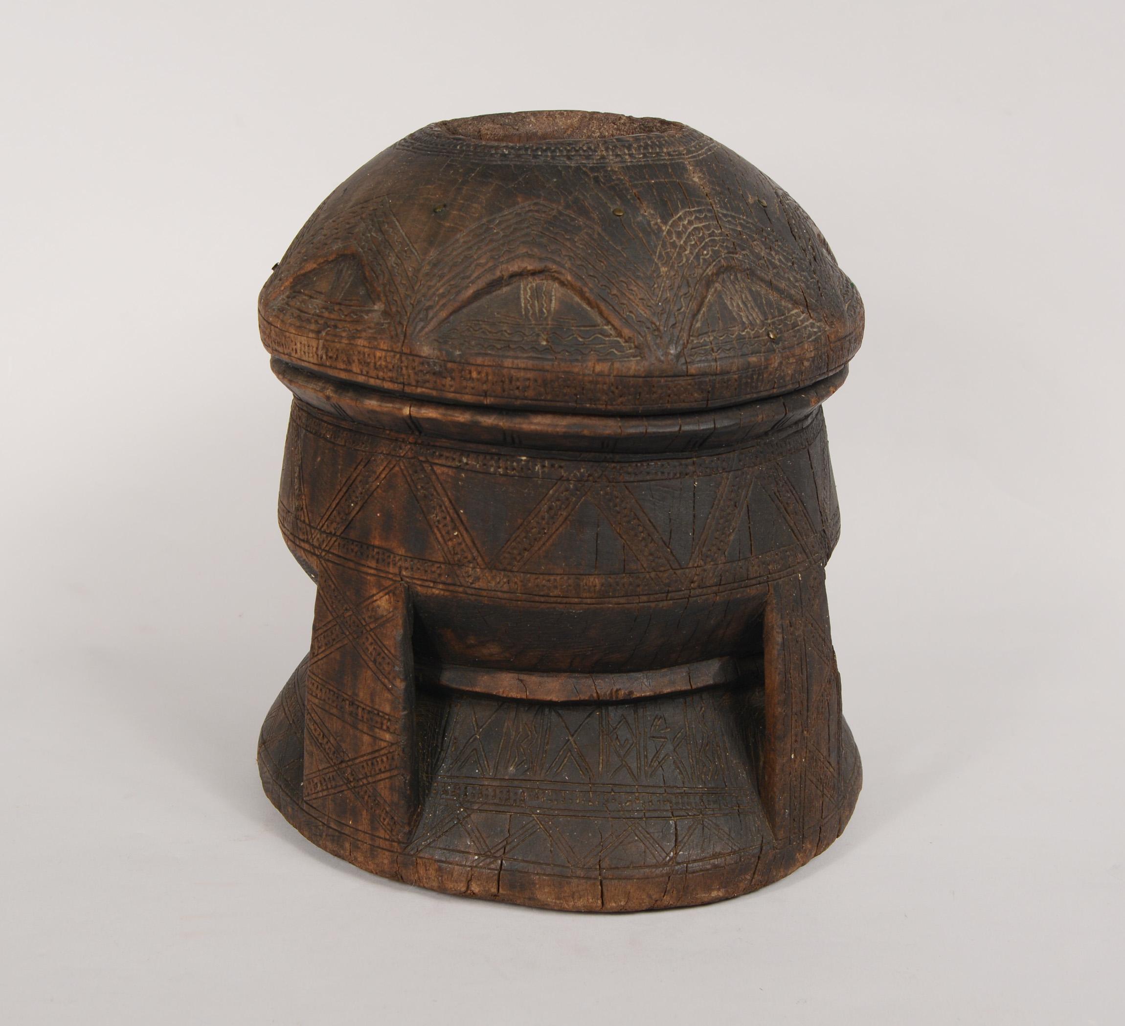 Hardwood mortar used for grinding coffee from Northern Africa. This mortar decorated with incised lines and small brass tacks. There are a couple of small losses.
