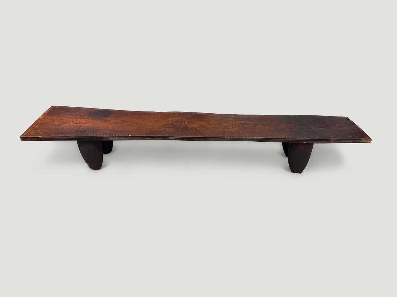 Magnifique table basse ou banc sculpté à la main dans un seul bloc de bois du Mali. Le bois est dur, dense et très durable. Le côté est finement sculpté et de minuscules triangles sont découpés sur le bord supérieur. Représenté avec des pieds en