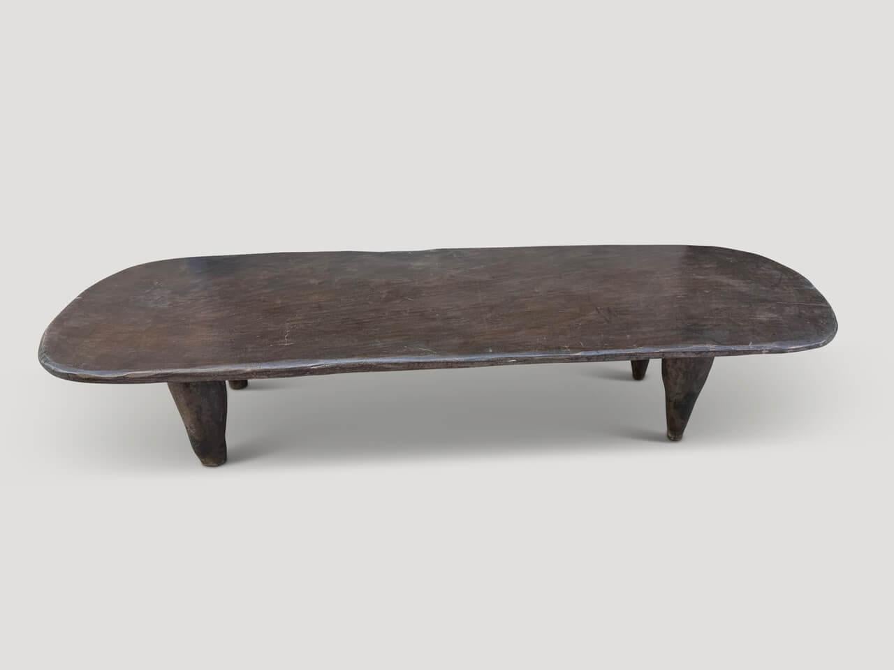 Antiker Couchtisch, handgeschnitzt von den Senufo-Stämmen aus einem einzigen Block Iroko-Holz, das an der Westküste Afrikas heimisch ist. Das Holz ist zäh, dicht und sehr dauerhaft. Abgebildet mit geschnitzten Beinen im Kegelstil. Wir beziehen nur