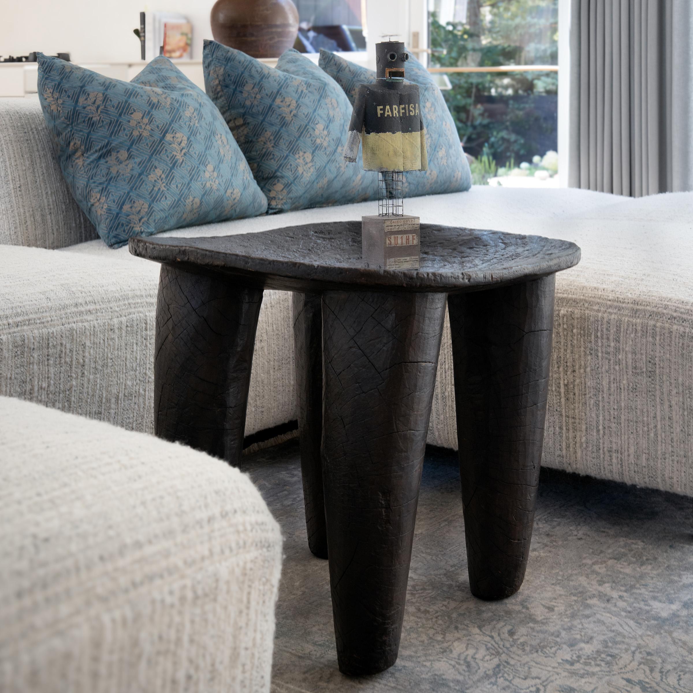 Hand-carved from a single, solid block of wood, each Senufo stool communicates a unique personality as a sculptural seat or table. This example from the early 20th century resonates strength, spirit and clarity, sculpted with a simplicity of form