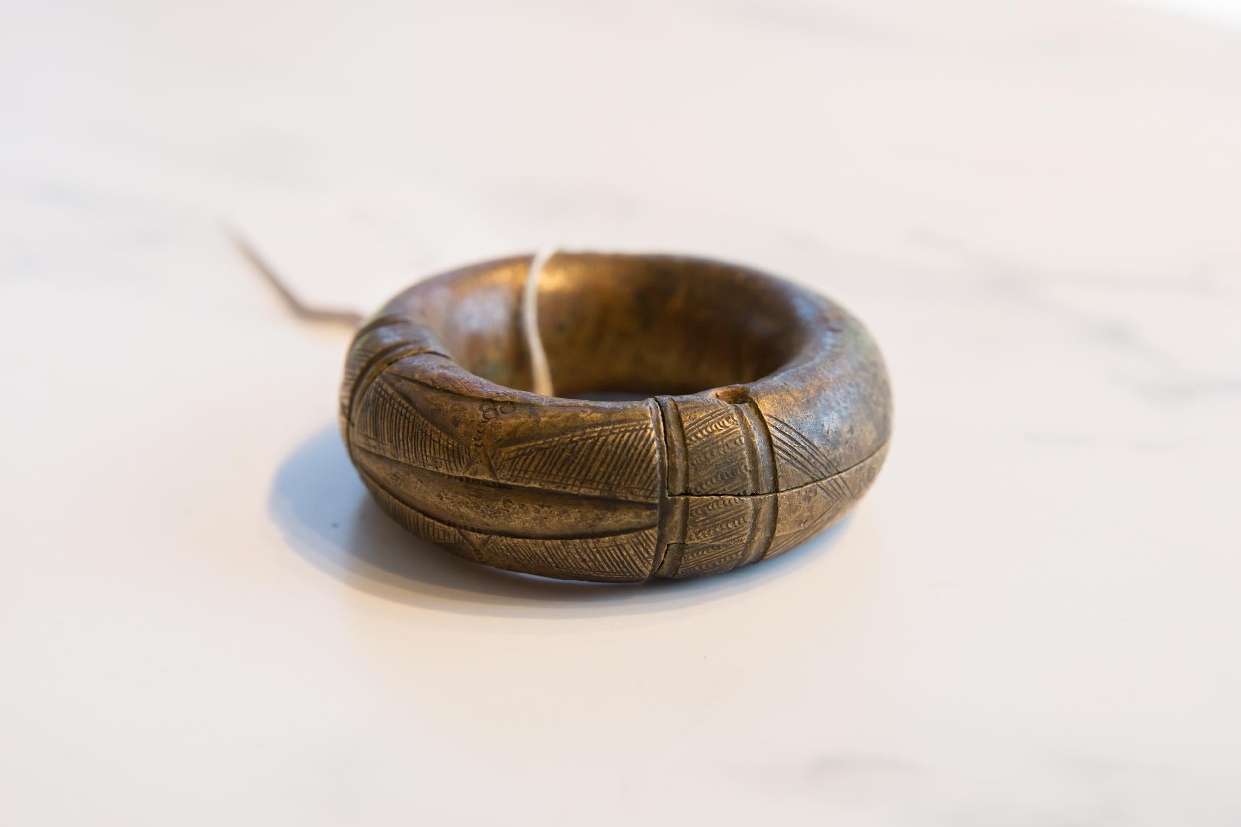 :: Antique handmade African small thick bronze bracelet with geometric detailing. Exceptional antique circa 19th century or older bracelet, possibly used as currency. This piece is unique collectible, with great craftsmanship having gone into its
