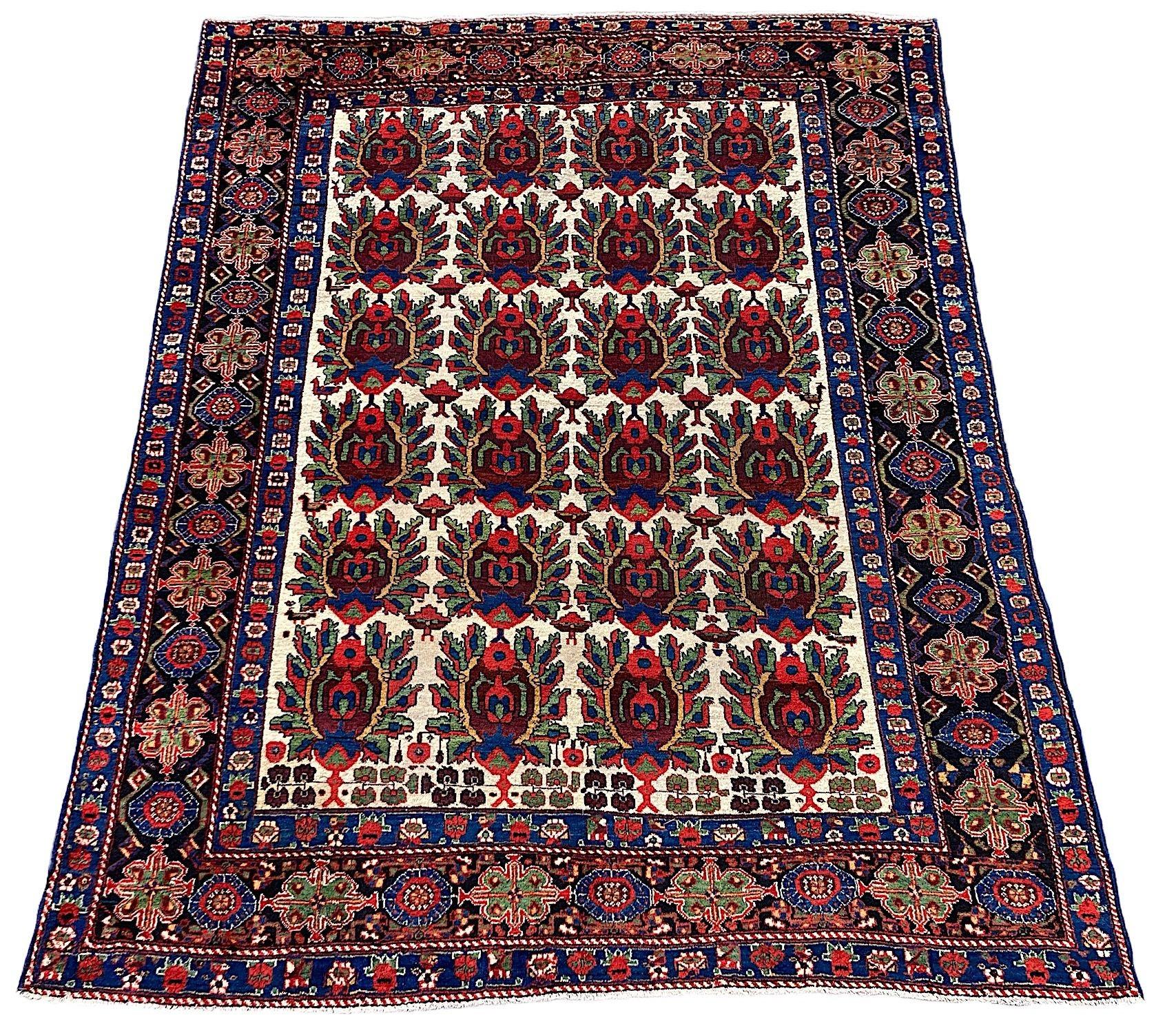 Un fabuleux tapis ancien Afshar, tissé à la main vers 1900. Le tapis présente un motif de bouclier répété sur un champ ivoire inhabituel entouré d'une bordure indigo profonde. Finement tissé avec de la laine douce et veloutée et des couleurs
