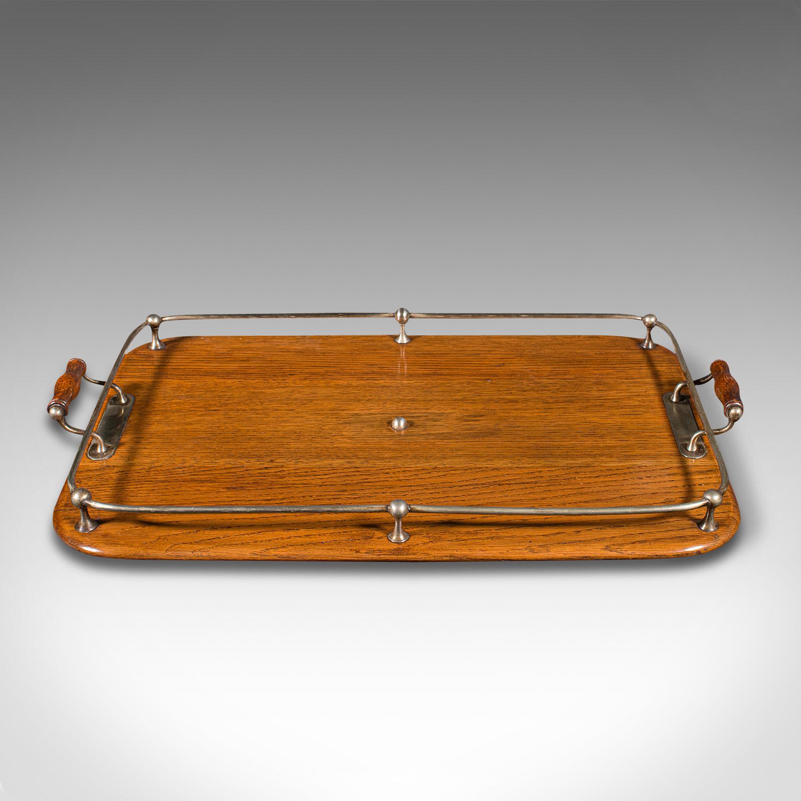 This is an antique afternoon tea tray. An English, oak and cast metal serving platter, dating to the Edwardian period, circa 1910.

Attractive serving tray with fine finish and colour
Displays a desirable aged patina and in good order
Select oak