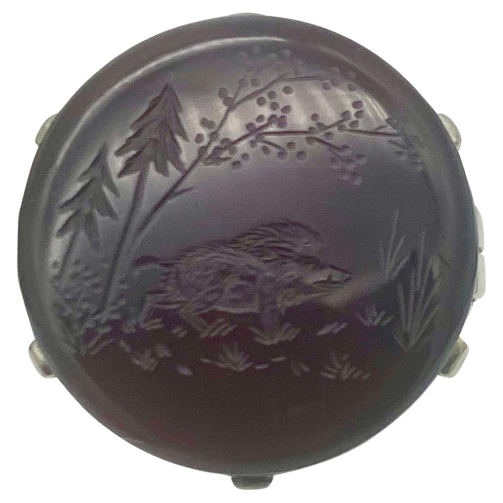 This charming Intaglio of a wild boar walking in a forest clearing has been engraved in a brown round agate with a slight red hue. The intaglio is mounted in a 14 karat white gold mount . The onside of the ring band is stamped with an Austrian