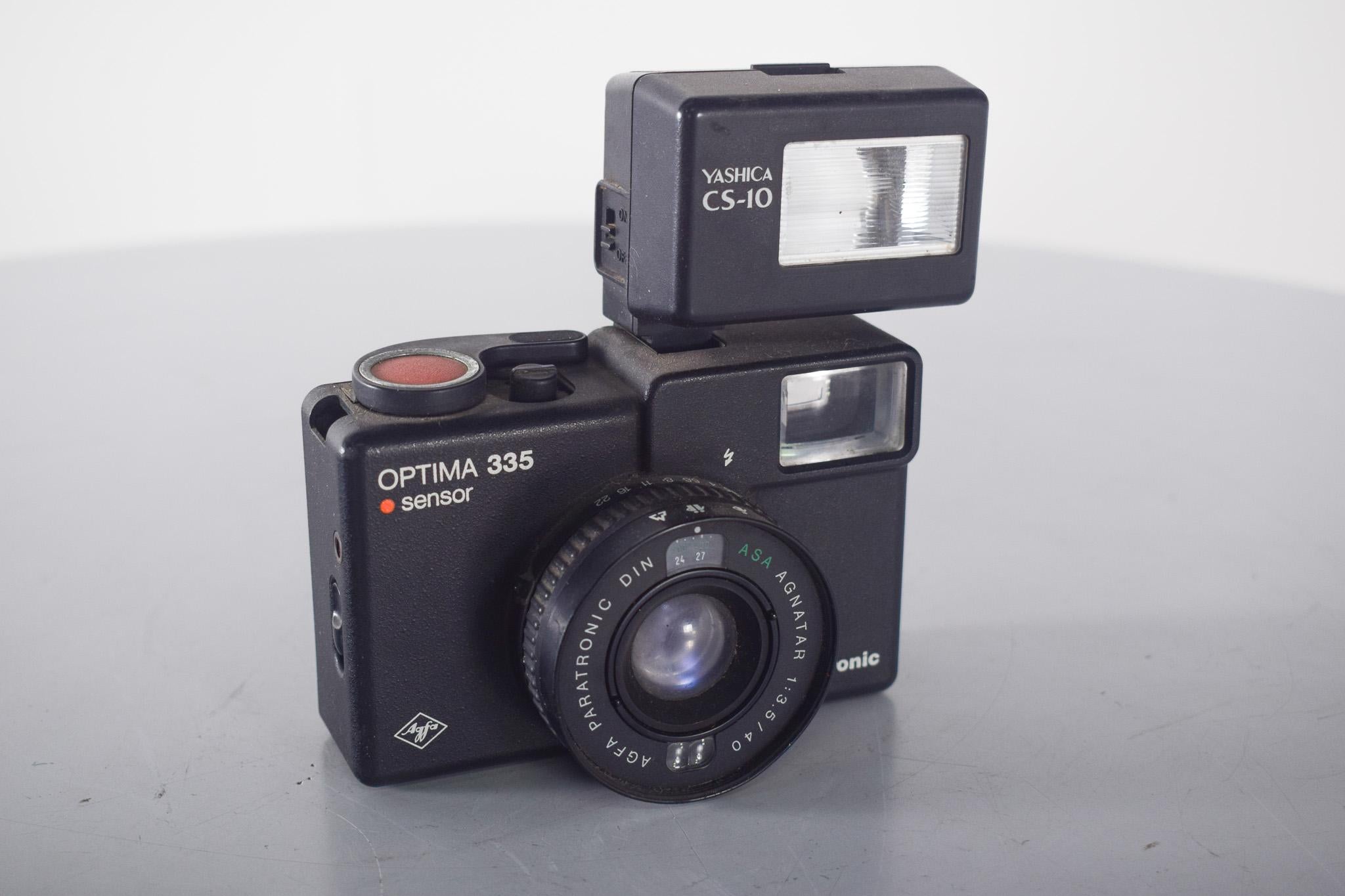 Agfa Camera, Optima 335. Agfa Camera, Optima 335. Appareil photo compact de 35 mm, produit par la marque allemande Agfa au cours des années 1970. Il est reconnu pour son design fonctionnel, ses lignes simples et sa facilité d'utilisation, des