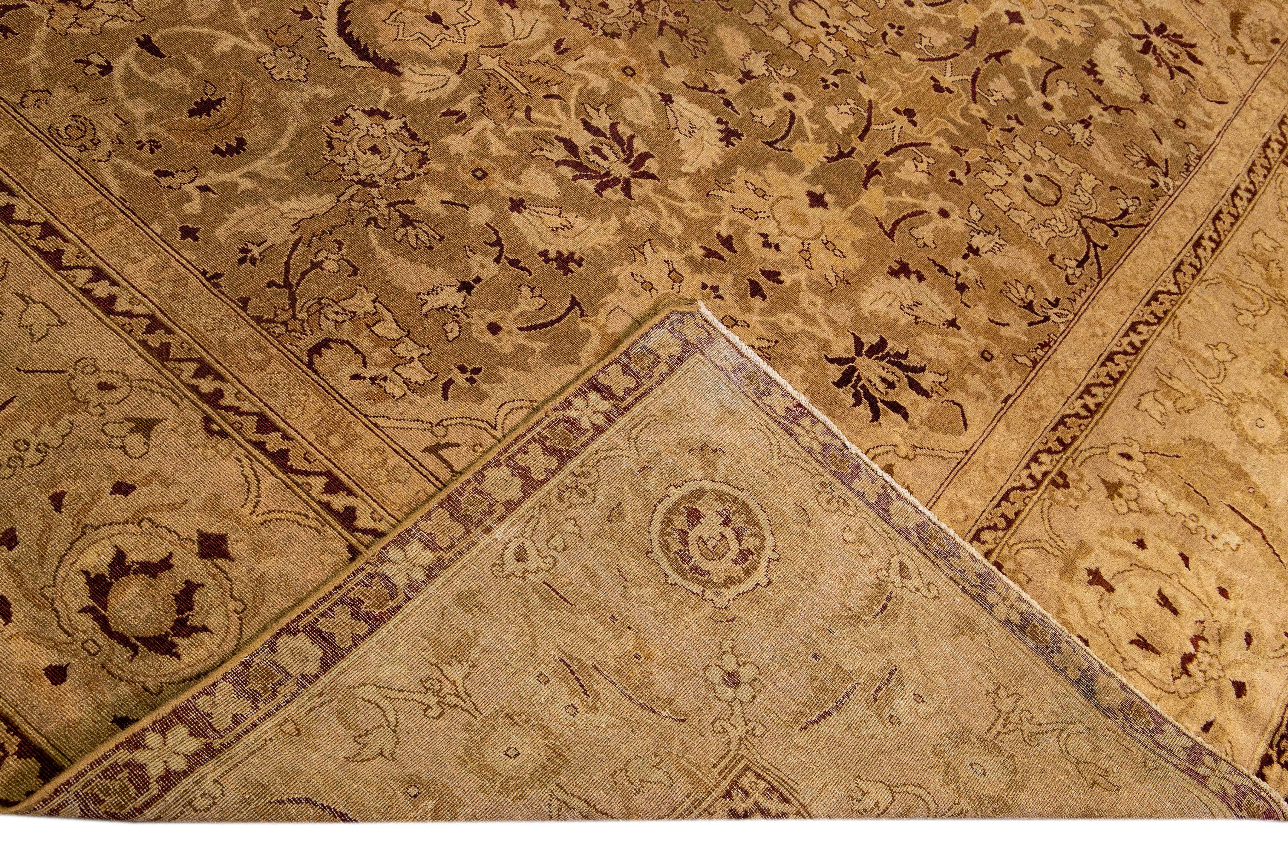 Beautiful antique Indian Agra hand-knotted wool rug with a medallion floral design on a tan field. This rug has accents of brown throughout the piece.

This rug measures: 10'8