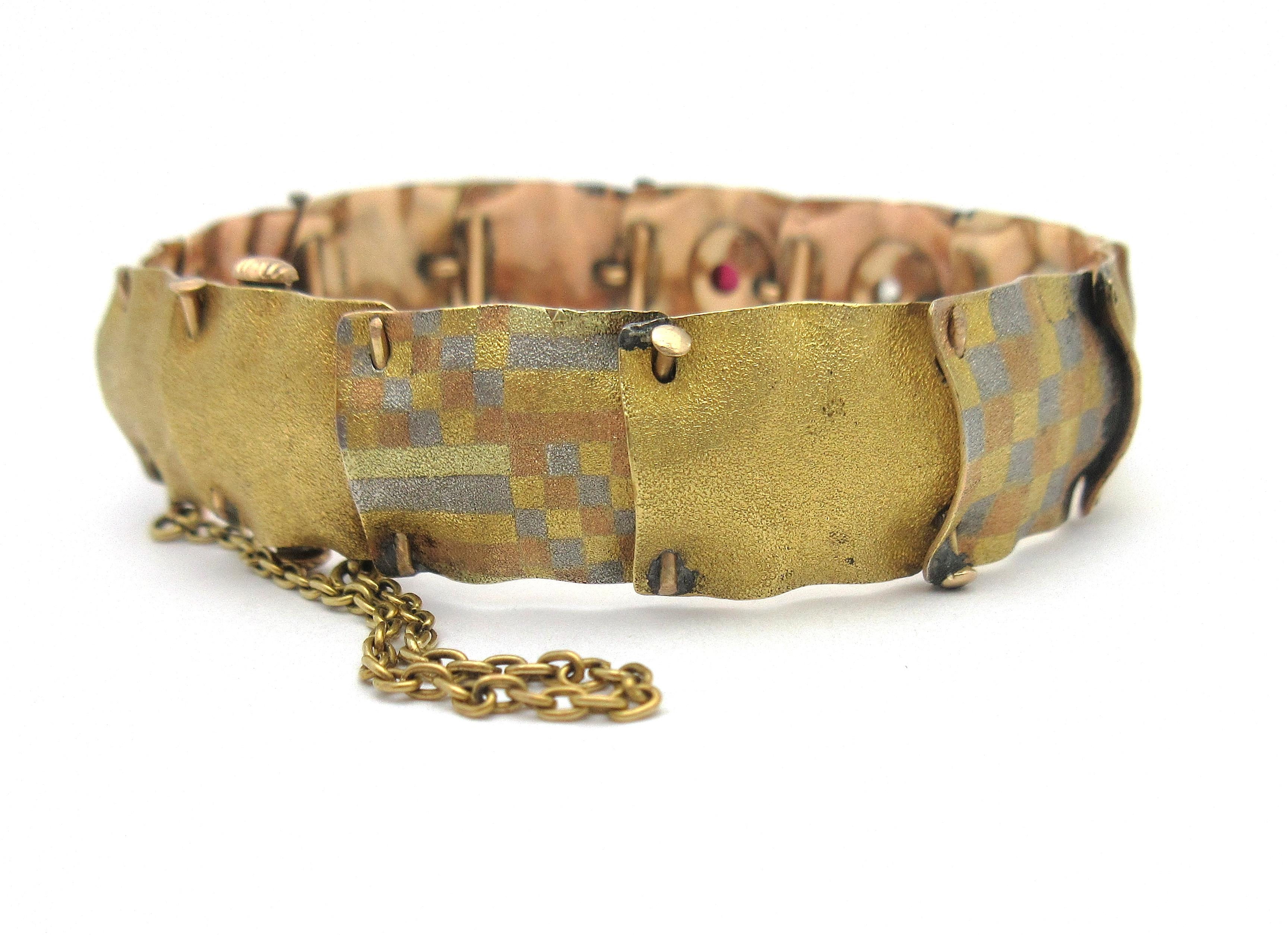 This beautiful antique bracelet by AJ Hedges & Co was made during the late 1800s.  The piece consists of flexible links resembling pinned fabric swatches with an overall bloomed texture.  Every other link incorporates tricolor 14 karat gold and