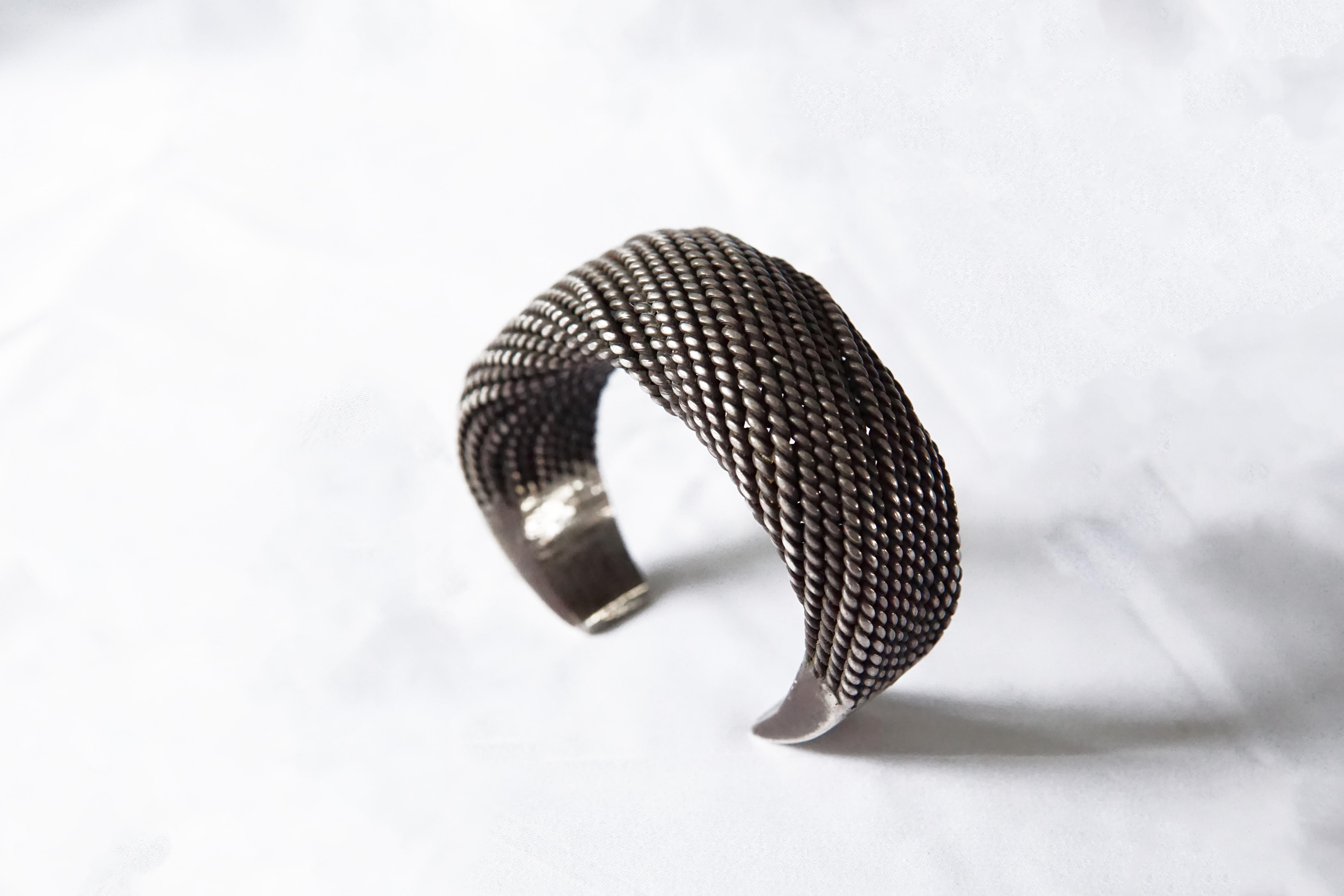 An Akha Tribe Woven Silver Bracelet with spiral design. This Tribal bracelet encompasses tradition Hill tribe silversmithing techniques with each silver strand crafted and woven by hand. This bracelet is slightly adjustable to fit different wrist