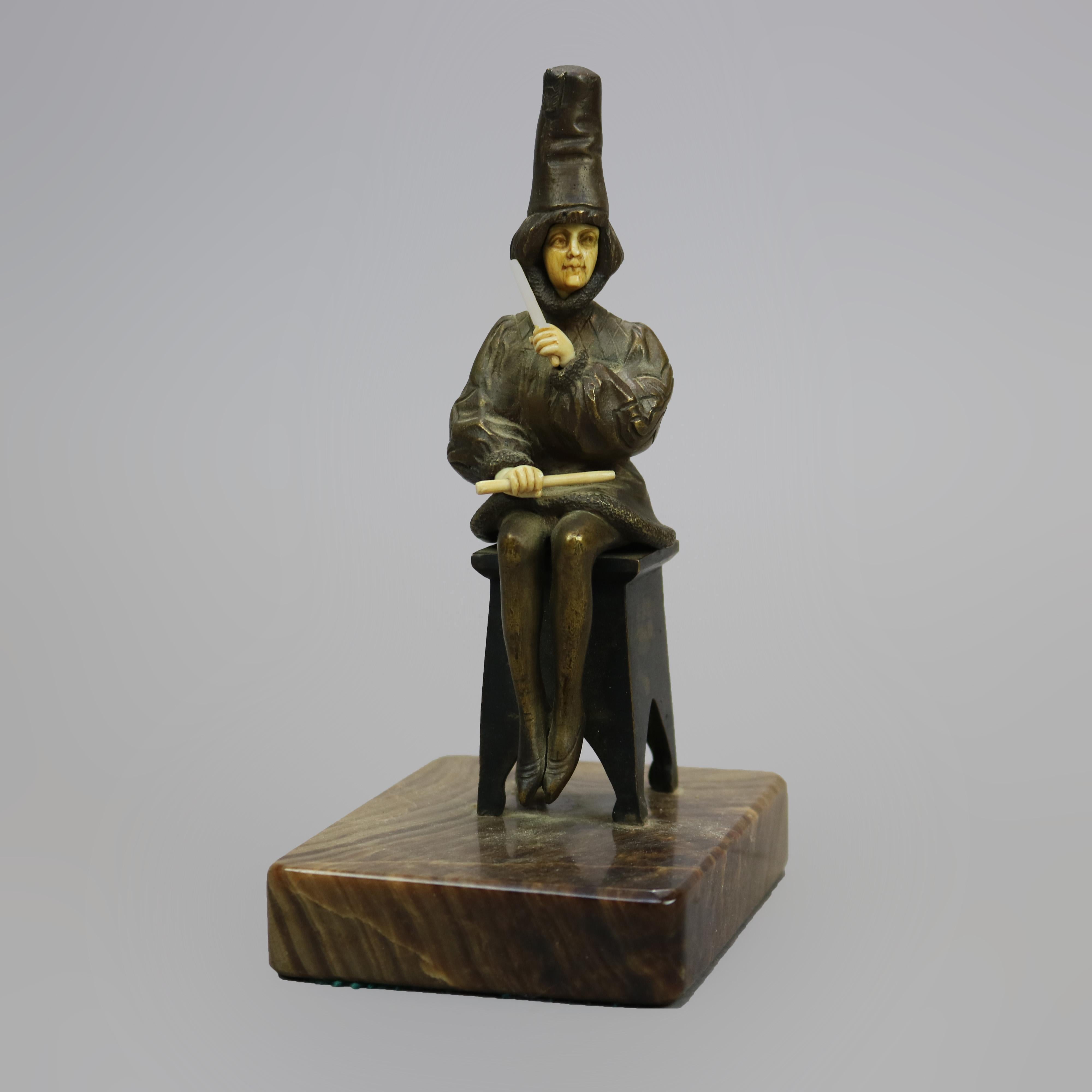 An antique bronze sculpture of a seated woman performer by Victor mounted on base with elements which appear to be carved bone, signed under seat 