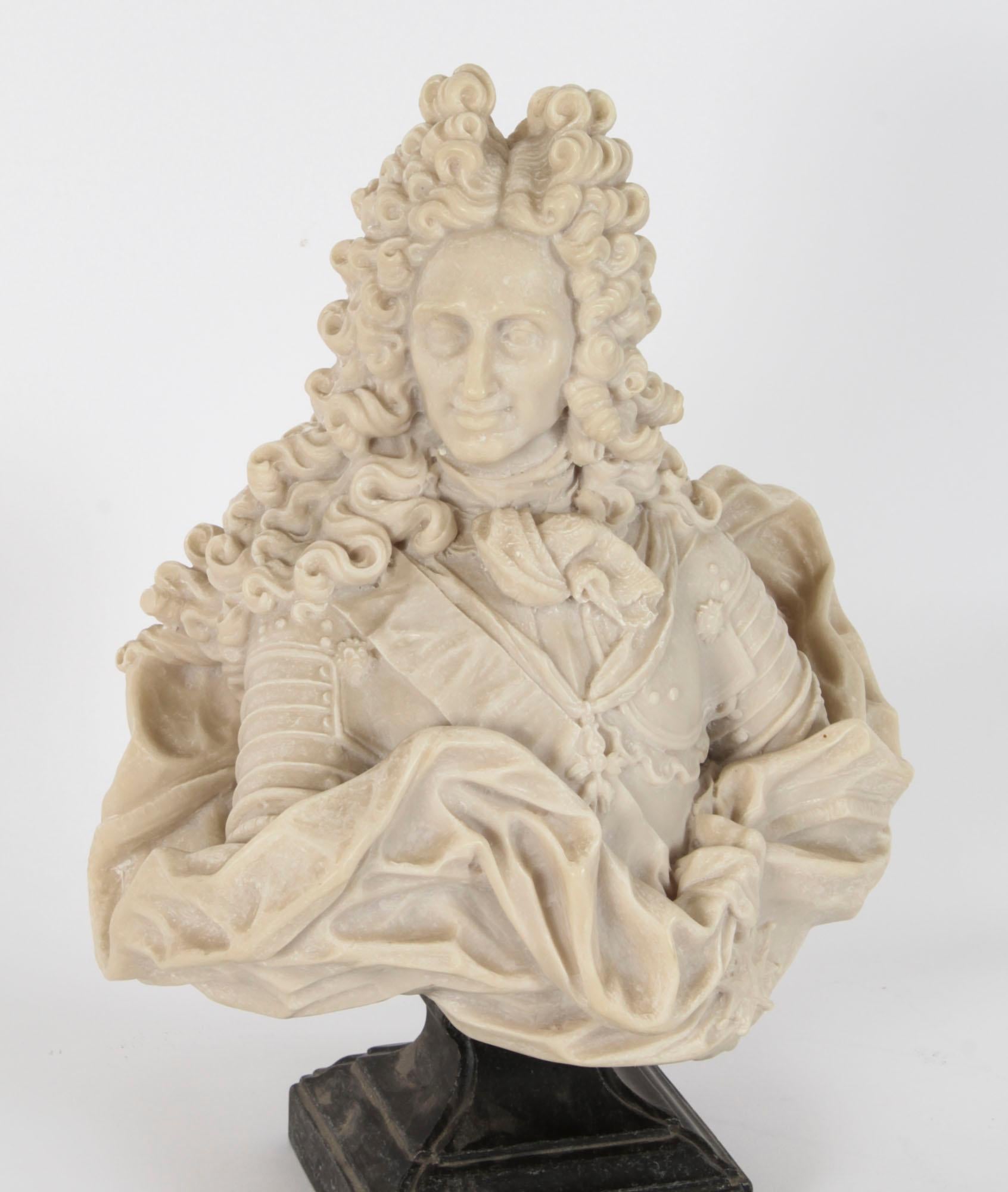 This is beautiful antique carved alabaster shoulder length bust of Philip V of Spain, after the antique and early 20th century in date.

The superb bust of King Philip V, with long a curls wig, draped with full body armour is mounted on a dark