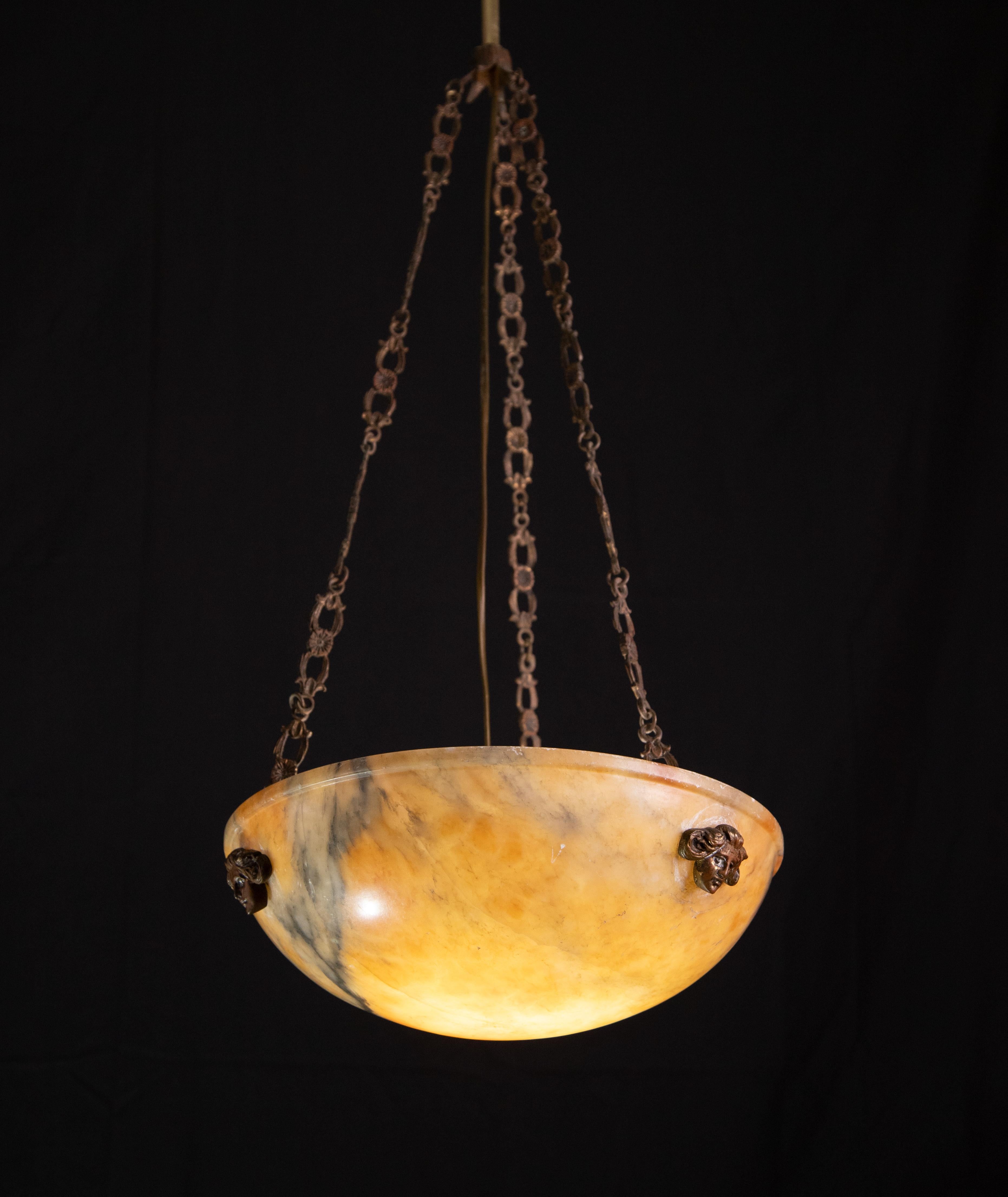 Antique orange alabaster hanging chandelier in Art Deco style, circa 1940s.
A unique piece in orange alabaster, beautifully worked with hues and reflections of other colors when lit, still suspended from the three original chains, the chandelier is