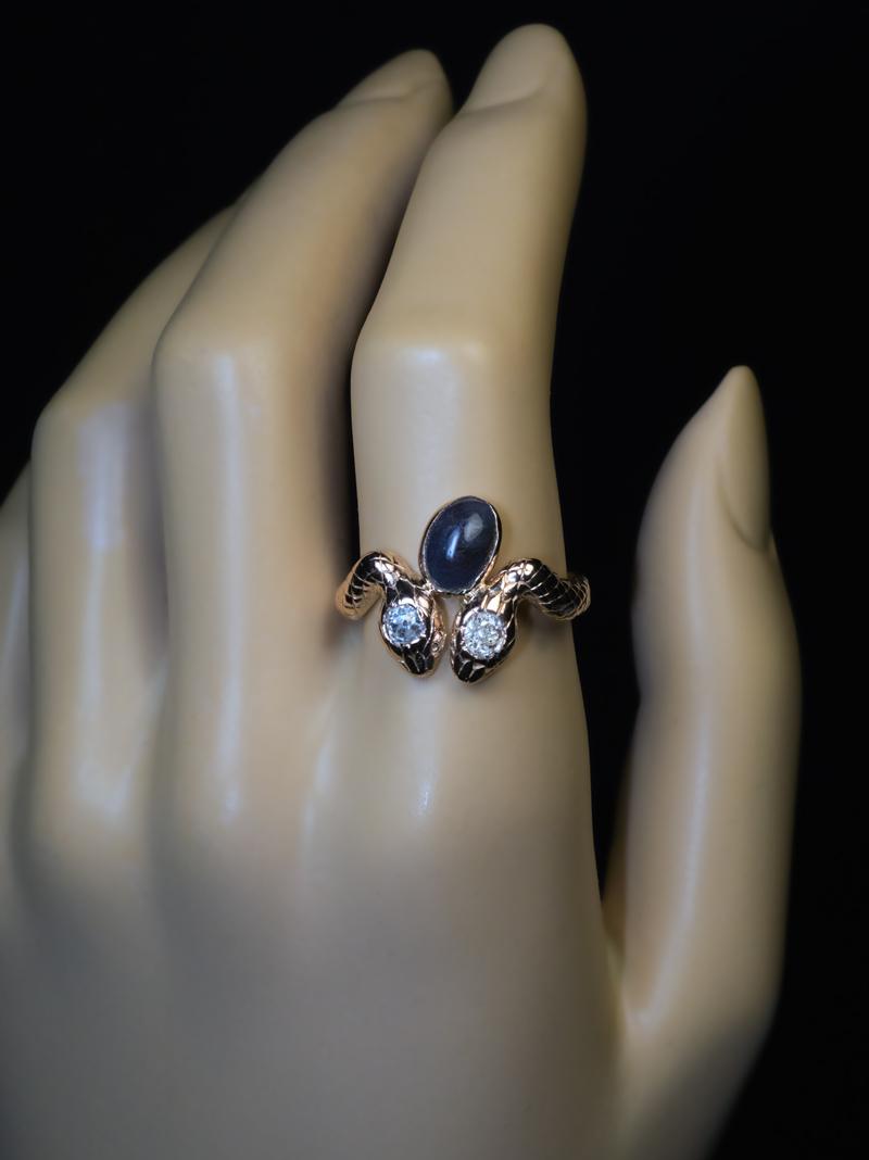 Circa 1880s-1890s.

This antique Egyptian revival 14K gold ring is finely modeled as a pair of hand-engraved snakes.  The ring is embellished with two old mine cut diamonds and a bezel-set cabochon cut Alexandrite.

The Alexandrite measures 9.1 x