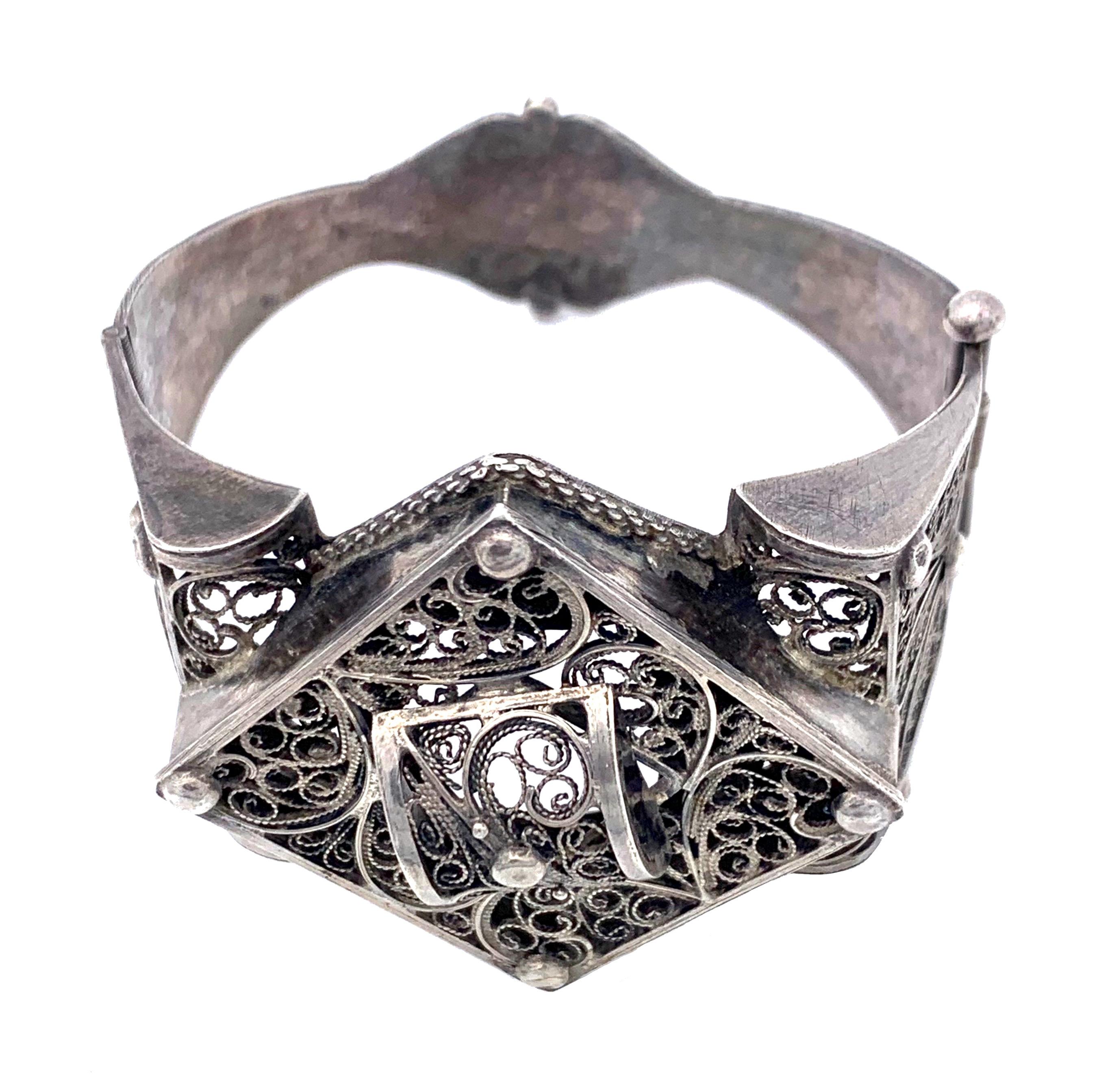 This exquisitely worked silver bracelet has been handcrafted in North Africa around 1920. A square silver frame is decorated with openwork silver wire scrolls.The bracelet is in fine original condition.   