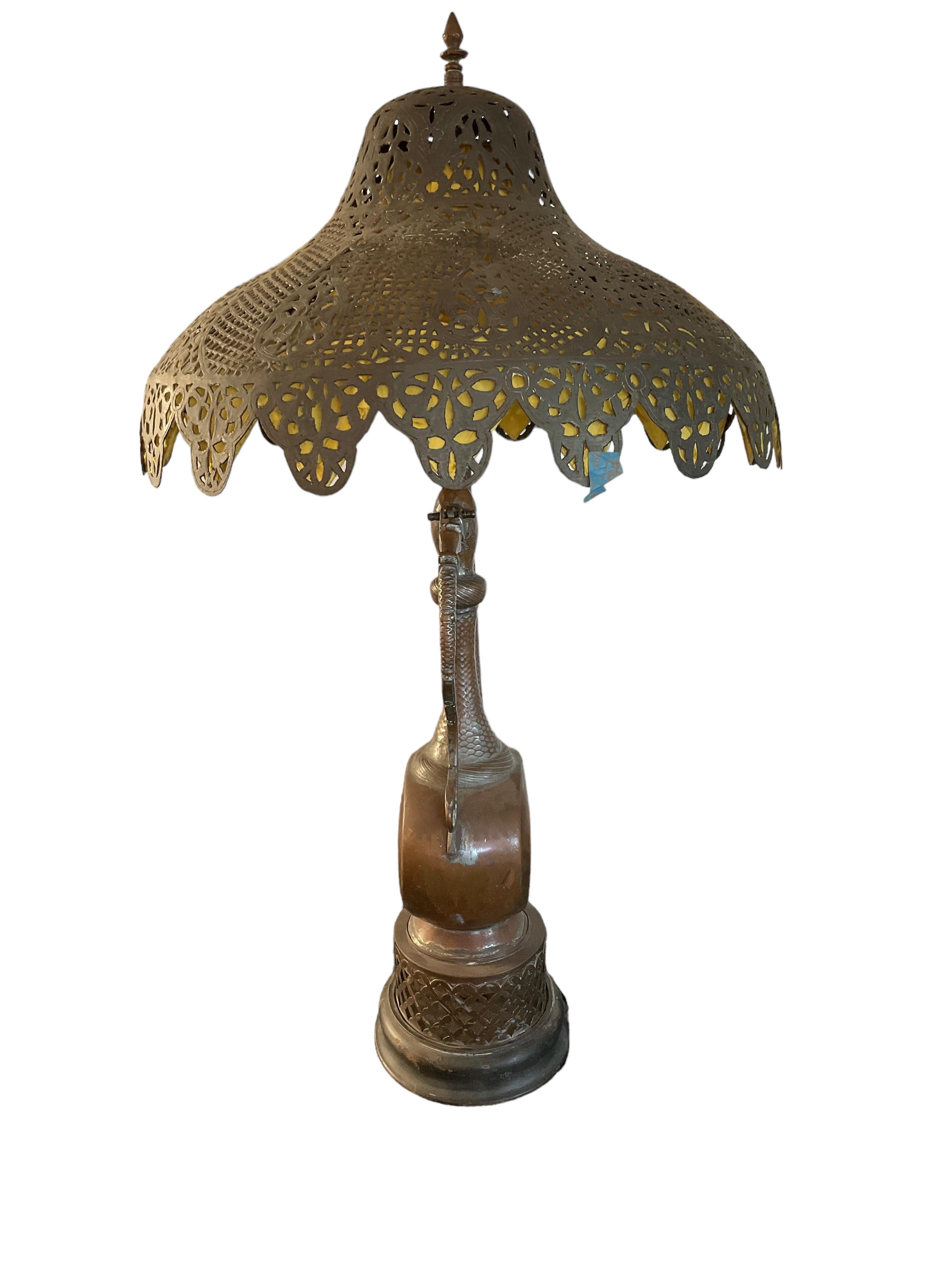 This Moroccan lamp is unlike any I have seen in my 30 years in the business. The pierced lampshade is incredibly beautiful and it is lined with yellow silk which is attached to the lamp with hand stitching. The matching base is a unique copper ewer.