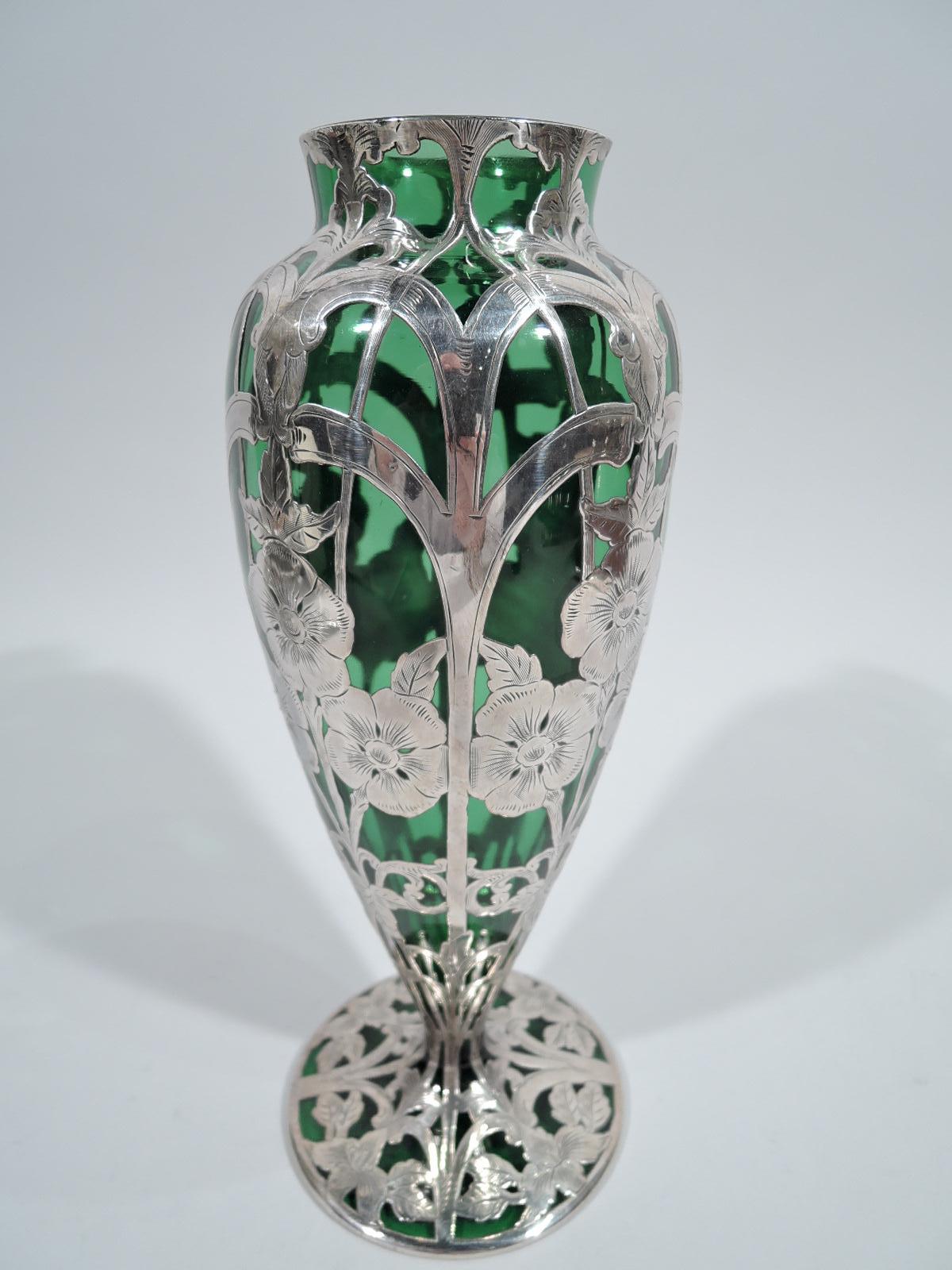 Turn-of-the-century Art Nouveau glass vase with engraved silver overlay. Ovoid with short and straight neck, and flat and round foot. Overlay in form of stem flowers on vertical trellis lines with double arcade. Glass is green. Fully marked
