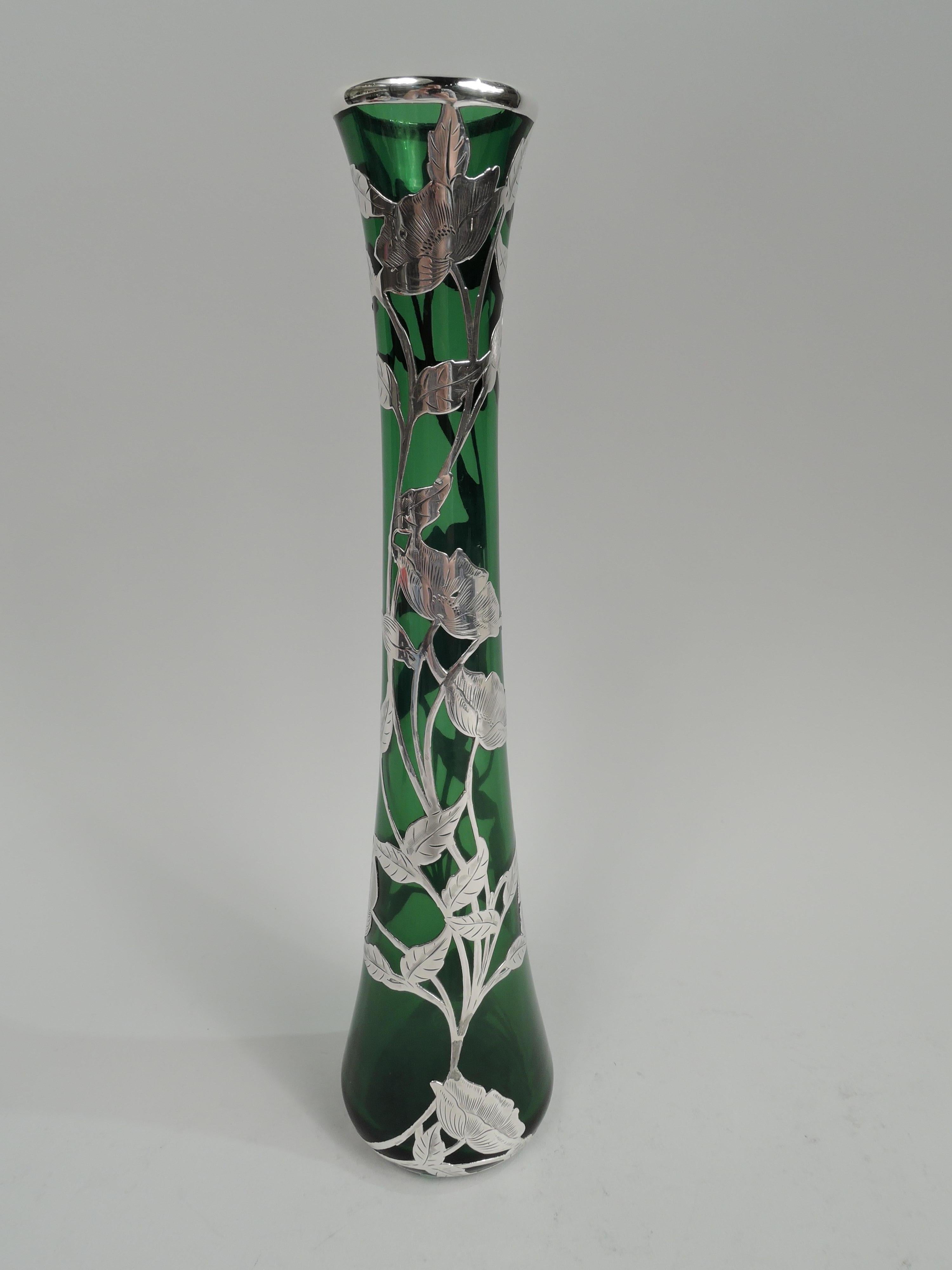 Turn-of-the-century Art Nouveau glass vase with engraved silver overlay. Made by Alvin Corp. in Providence. Conical with tall neck and gently flared rim. Overlay in form of entwined and climbing flowering and leafing branches as well as elongated