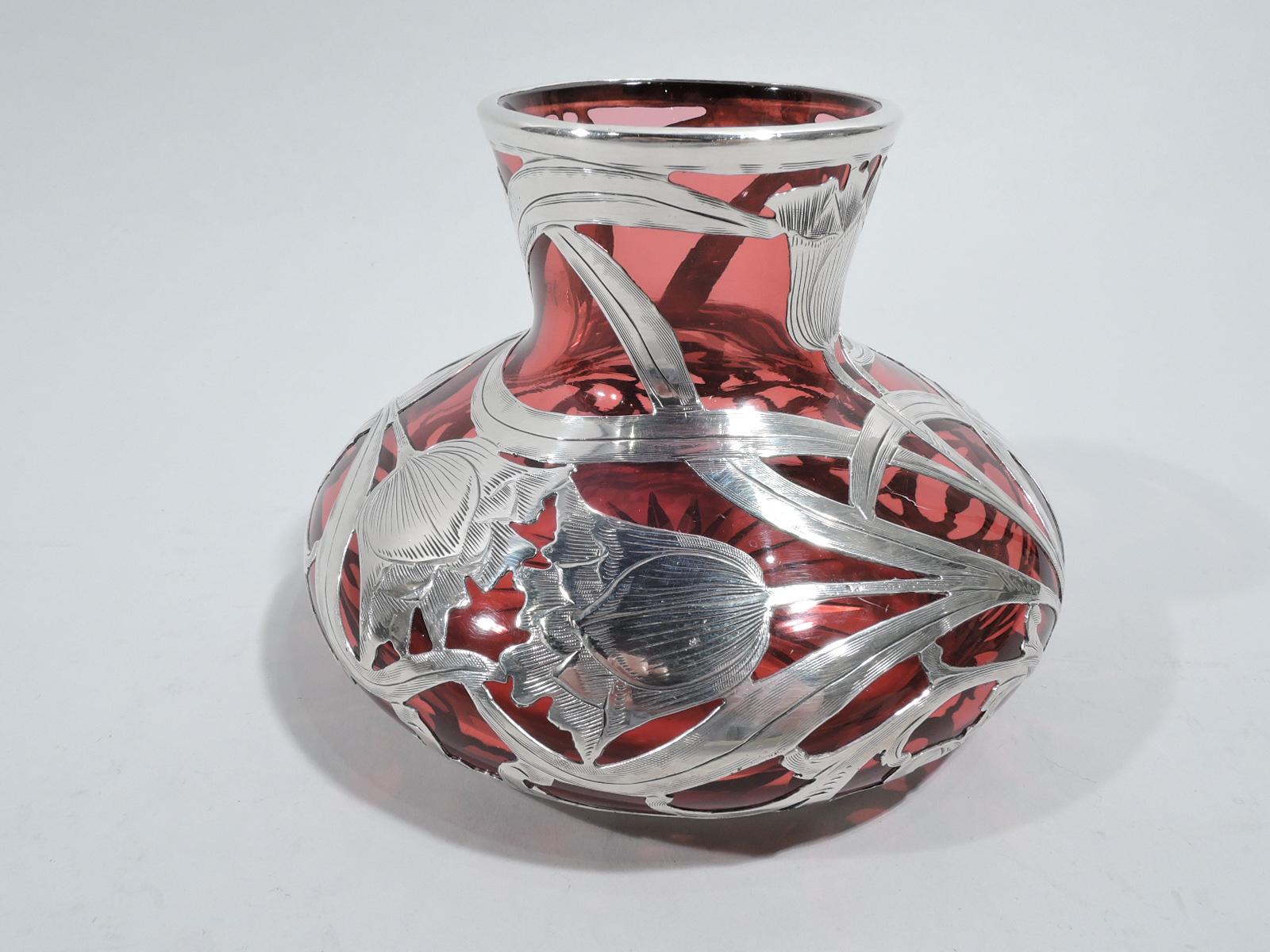 Turn-of-the-century Art Nouveau glass vase with engraved silver overlay. Made by Alvin in Providence. Bellied bowl and short and flared neck. Loose and dynamic pattern comprising flower heads with entwined stems and tendrils. Star cut to underside.