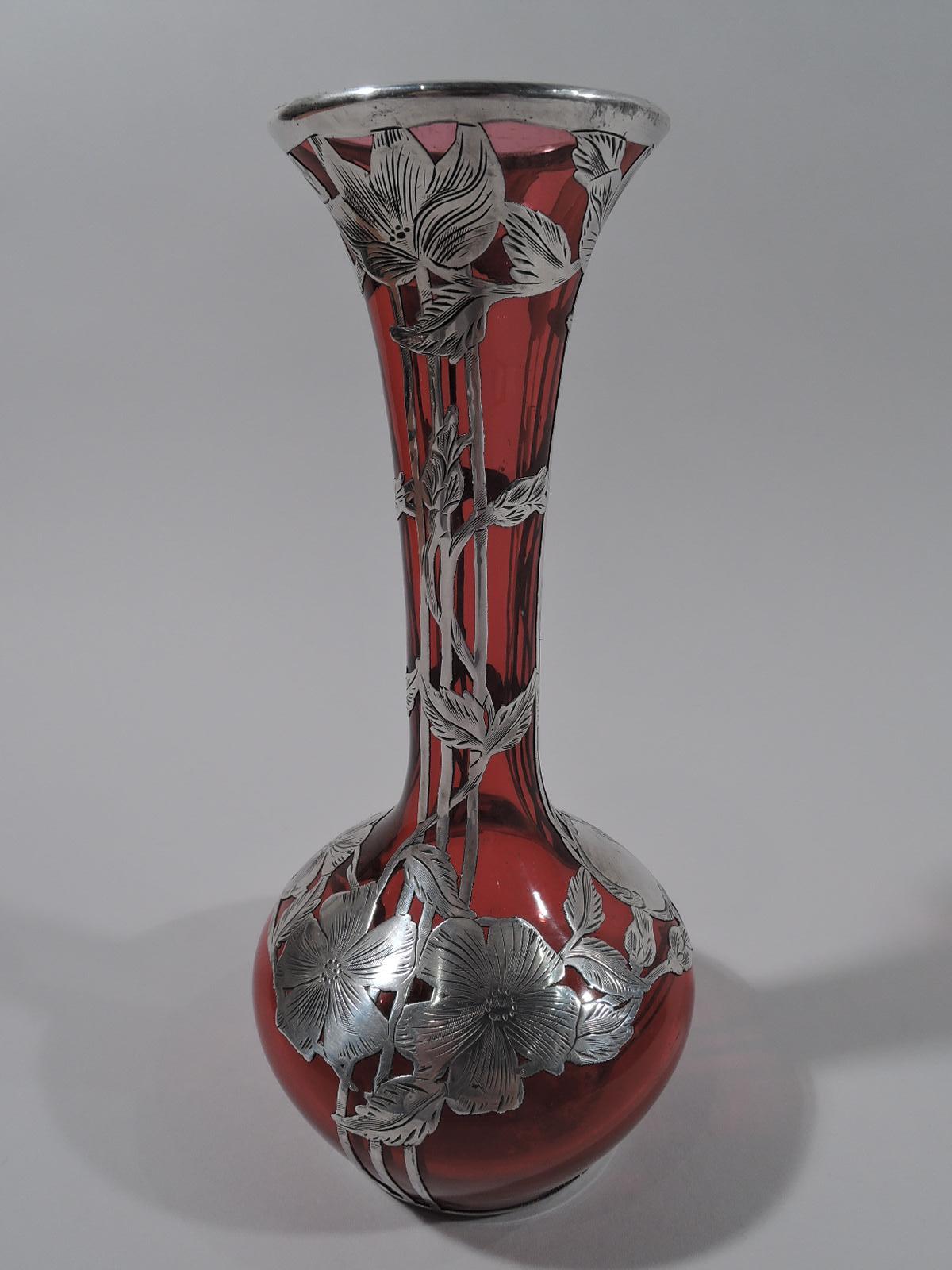 Turn of the century Art Nouveau glass vase with engraved silver overlay. Ovoid bowl with tall cylindrical neck and flared mouth. Overlay comprises groups of vertical trellis lines entwined with stem flowers. Bowl shoulder has flower-head garland and