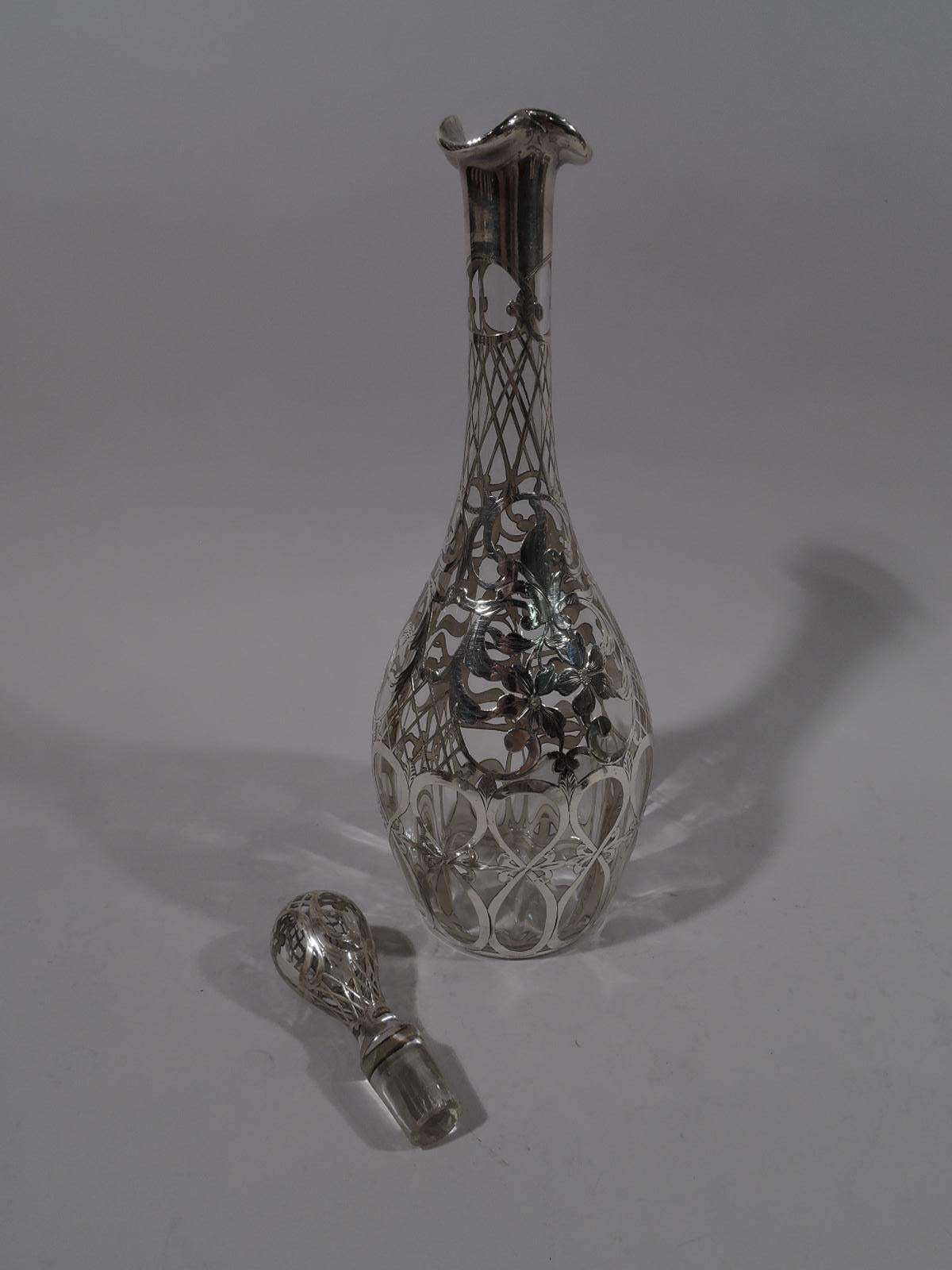 Turn-of-the-century Art Nouveau glass decanter with engraved silver overlay. Made by Alvin in Providence. Ovoid with cylindrical neck and ruffly trefoil mouth in silver collar. Stopper ovoid. Overlay in form flowers, leafing scrolls, and diaper.