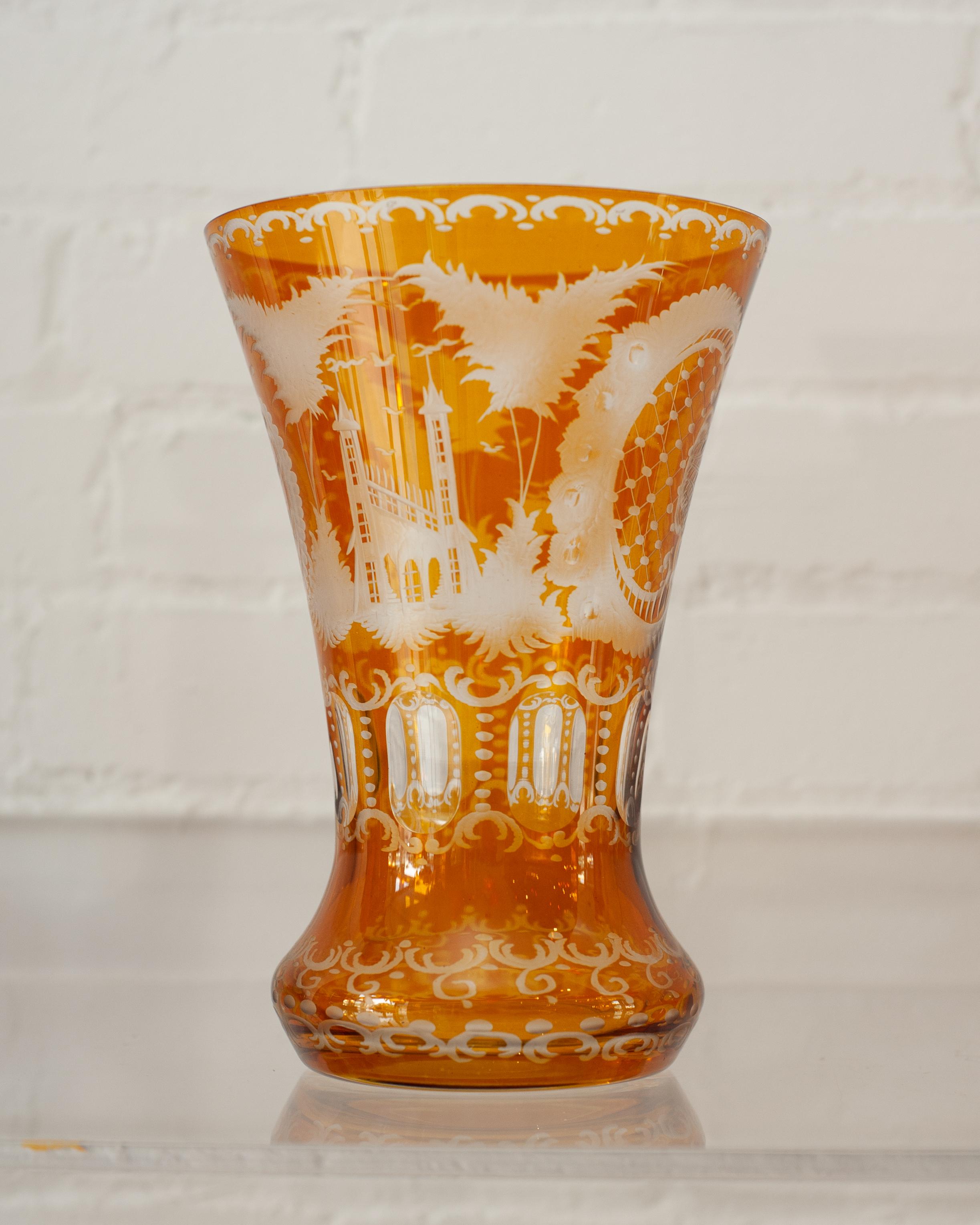 A large flared antique Bohemian amber glass vase with cut crystal ornate floral and cross hatch patterns. The artistry of the cut crystal makes this vessel as beautiful as the flowers you may put in them.